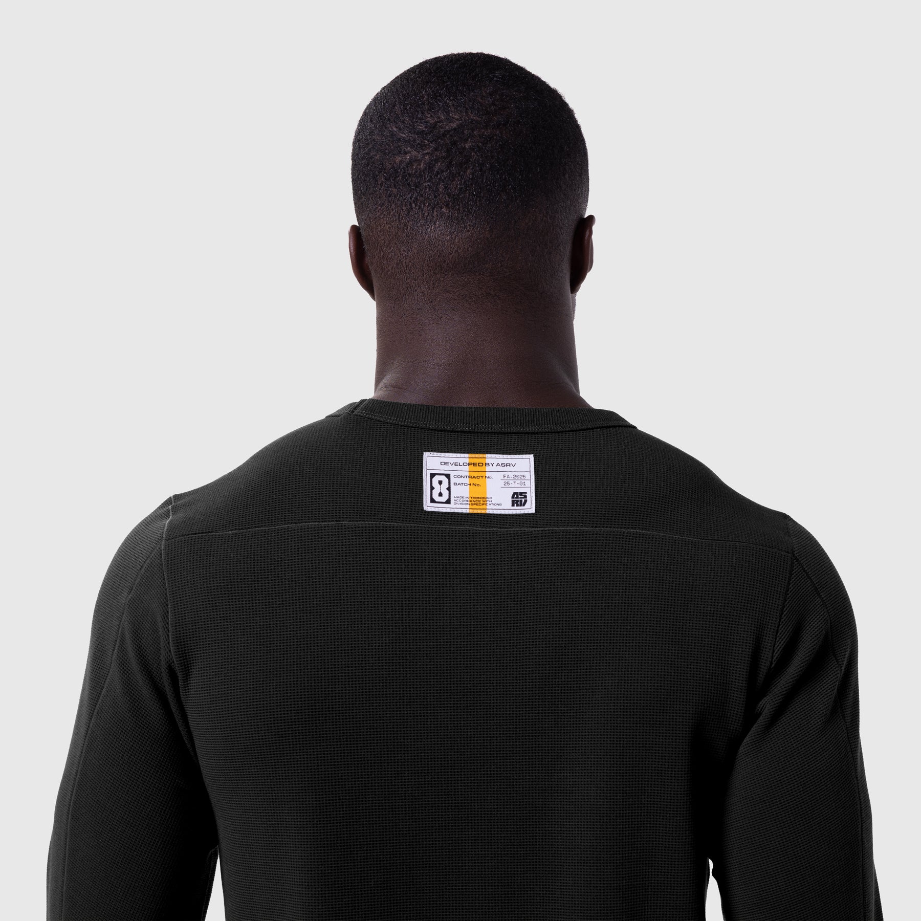 Black waffle knit longsleeve worn by model, back view with branded label visible