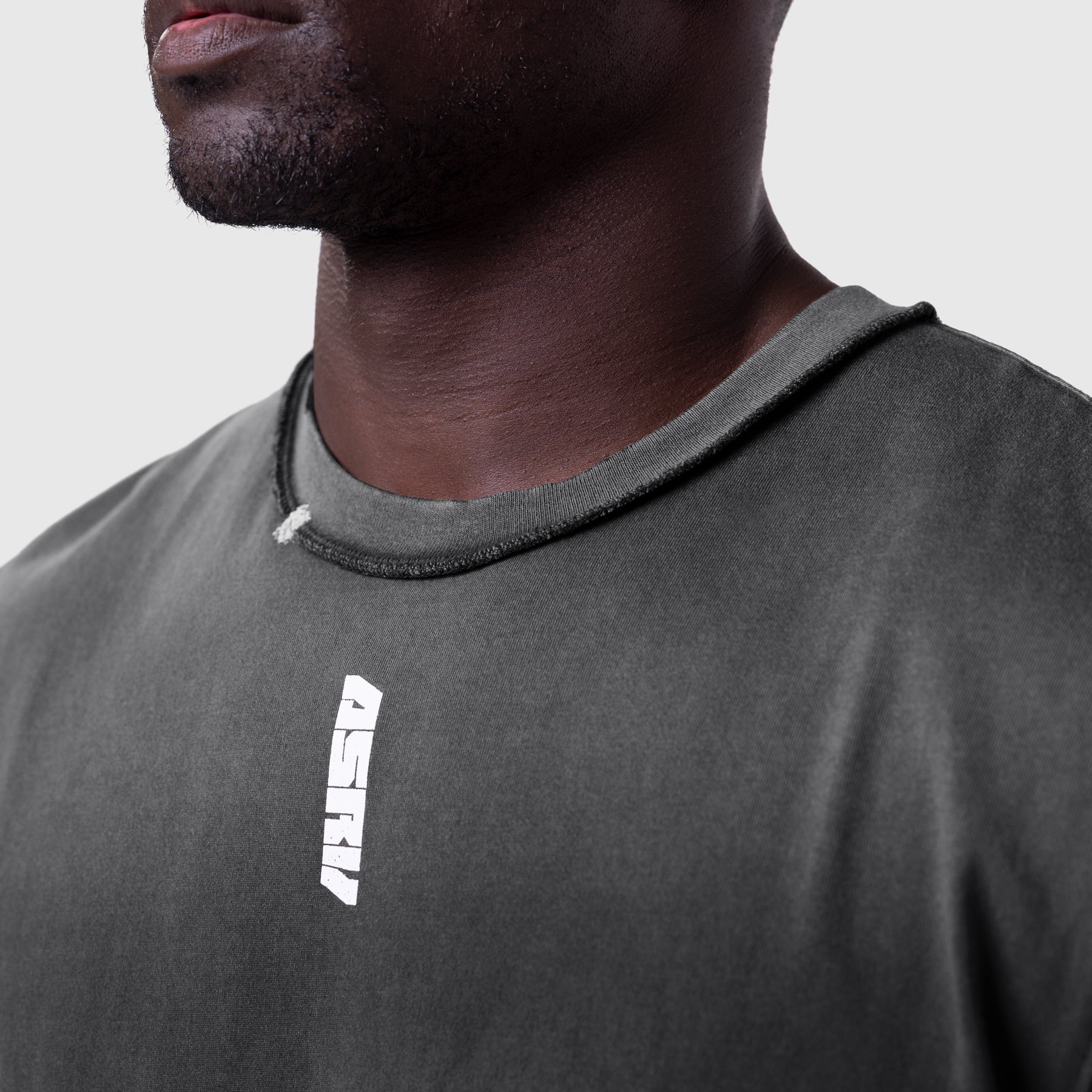 Tech Essential Cap Shoulder Cutoff in black sun fade, worn by model, front view