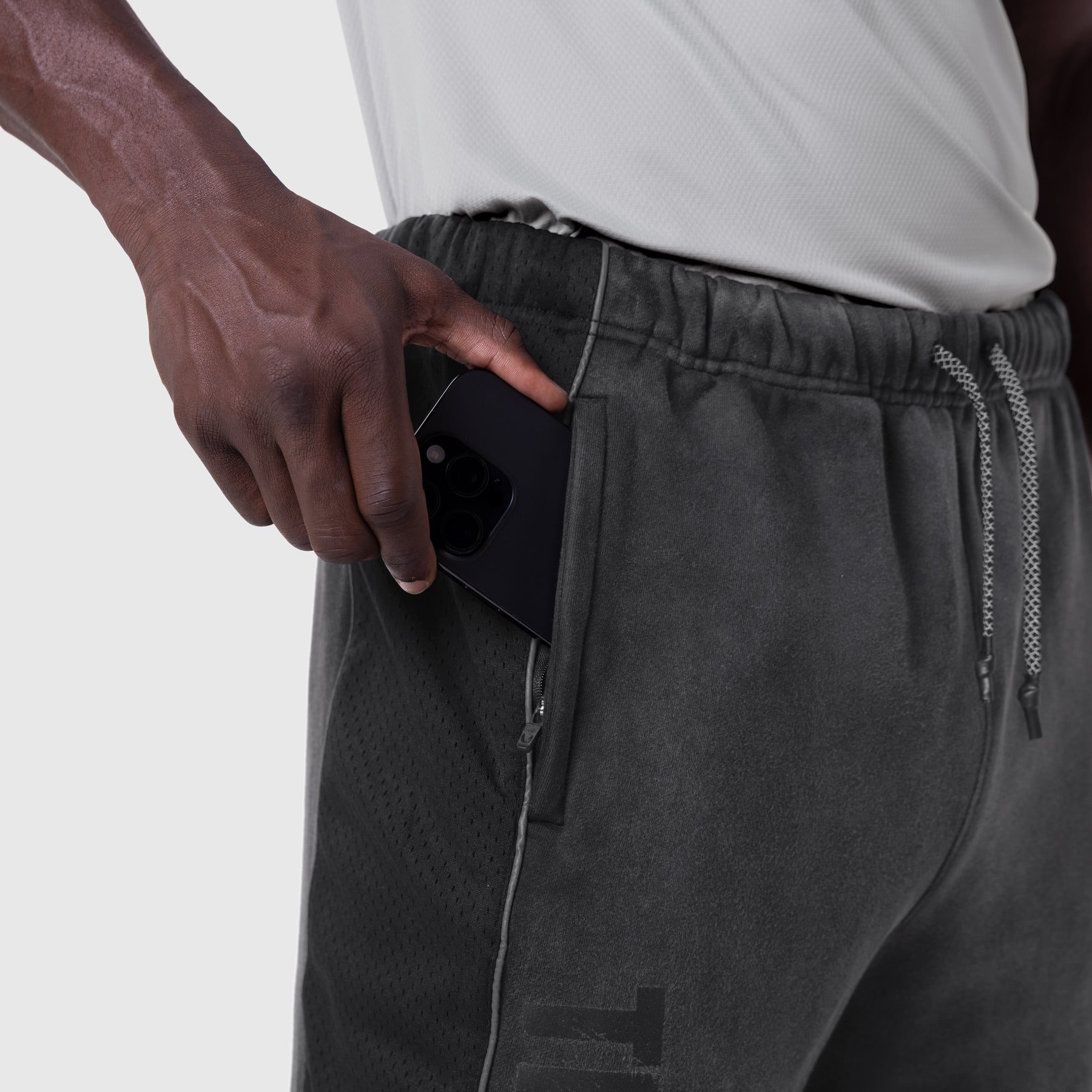 Black Tech-Terry mesh panel sweats worn by model with hand in pocket, side view