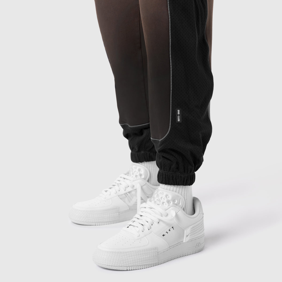 Tech-Terry Mesh Panel Sweats in black worn with white sneakers and white socks, lower body view