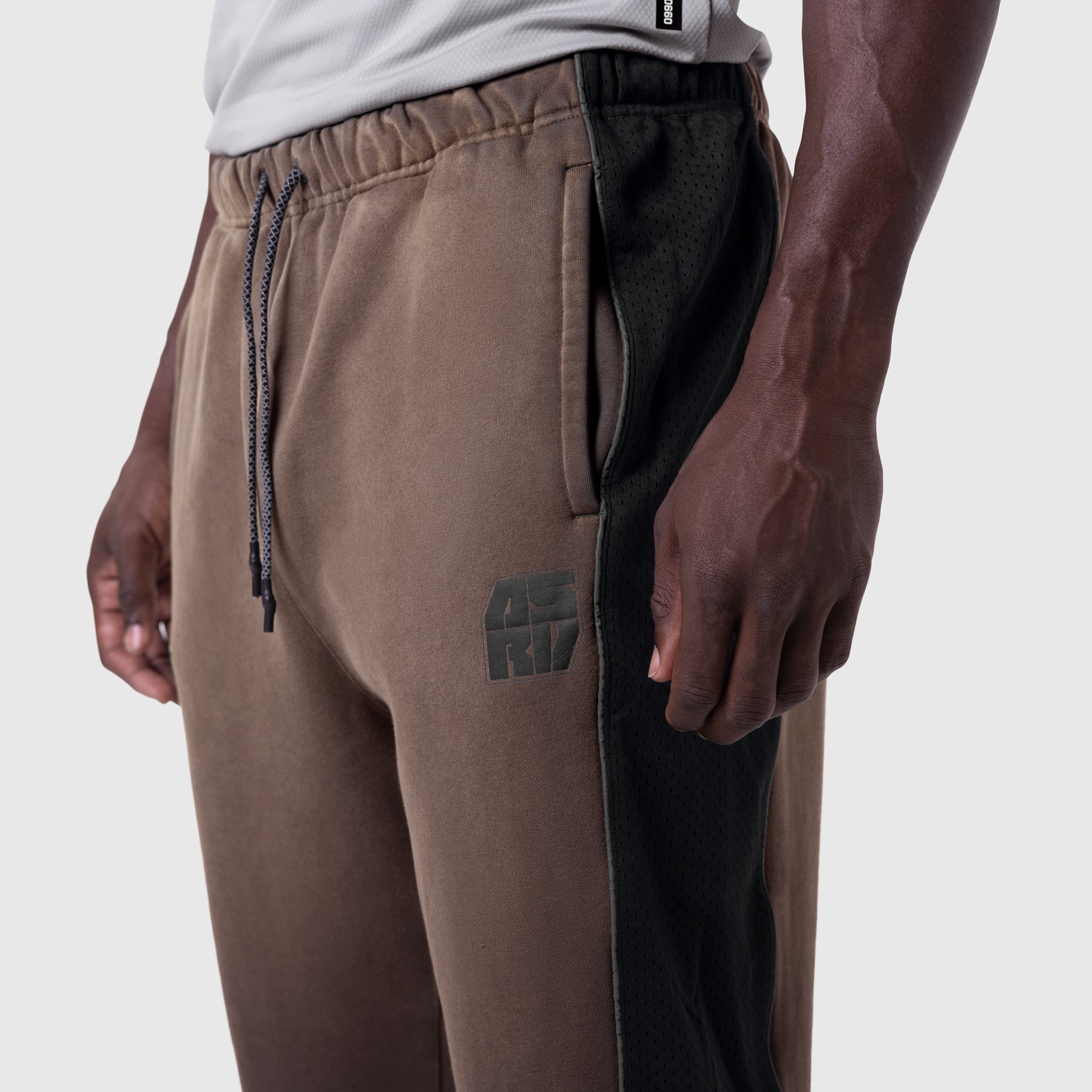 Tech-Terry Mesh Panel Sweats in dark earth with black side panels, worn by model, side view