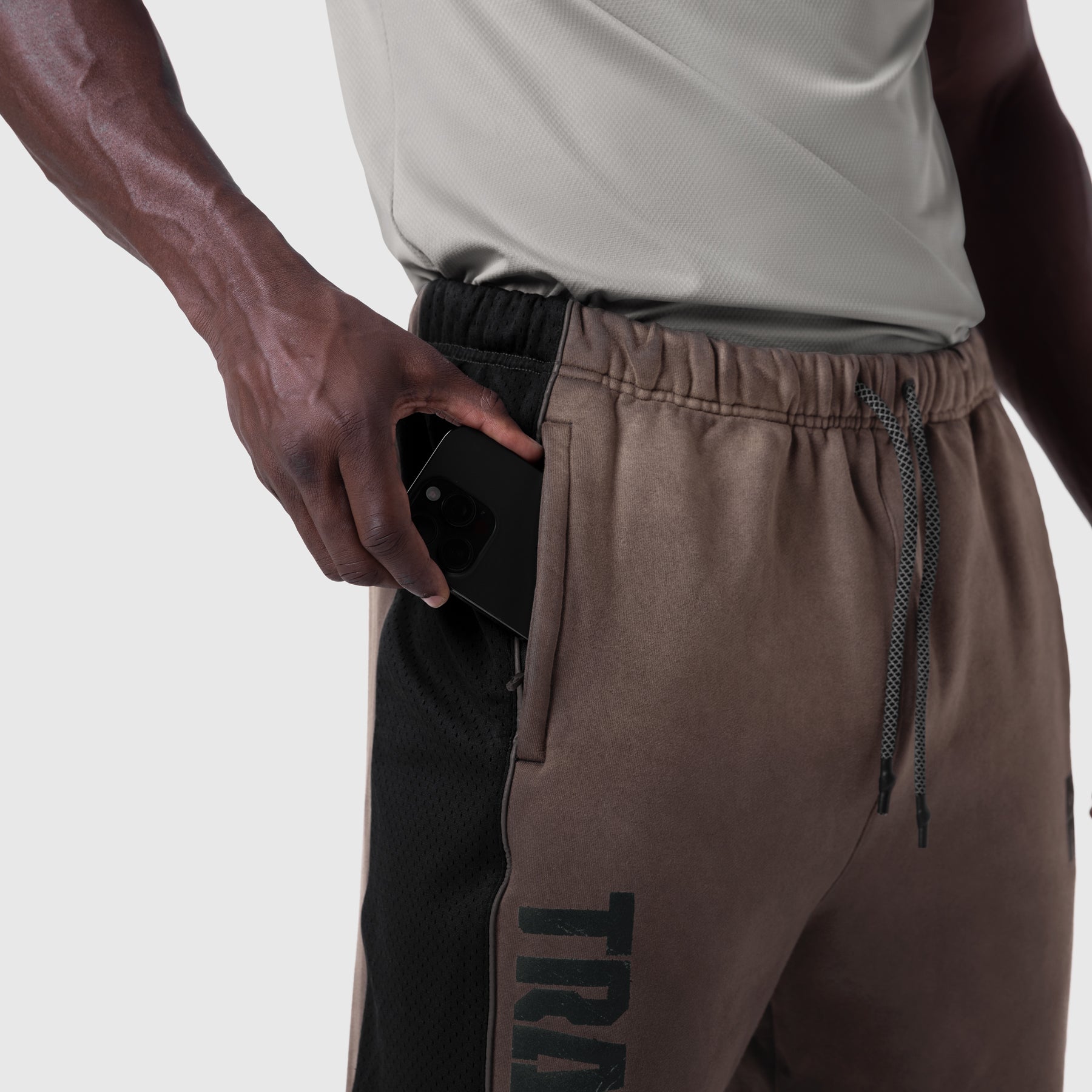 Tech-Terry Mesh Panel Sweats in Dark Earth, model wearing and holding phone in pocket