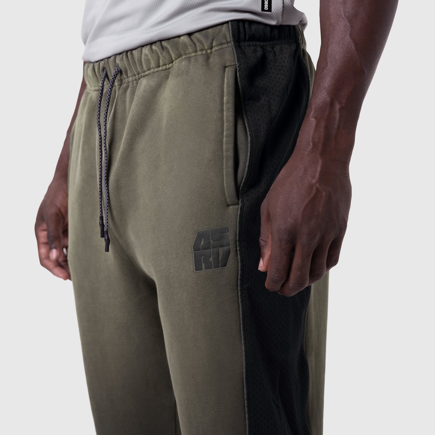 Tech-Terry Mesh Panel Sweats in olive with black mesh panels, side view on model