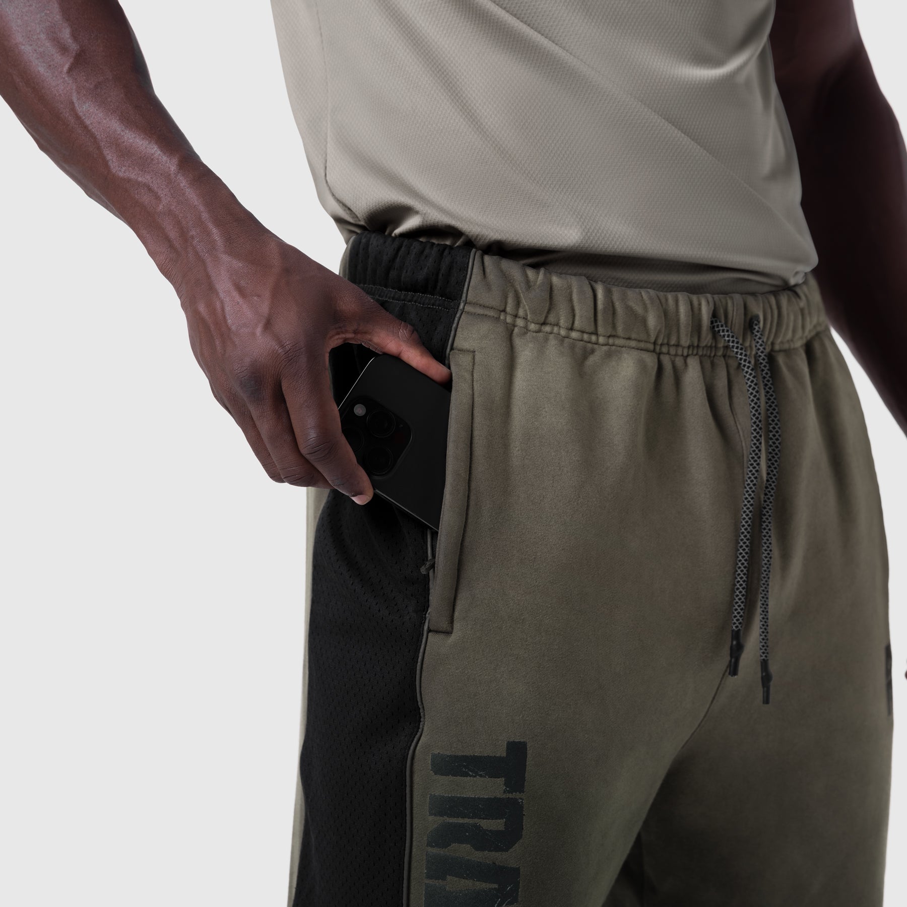 Tech-Terry Mesh Panel Sweats in olive, model wearing and holding phone in pocket