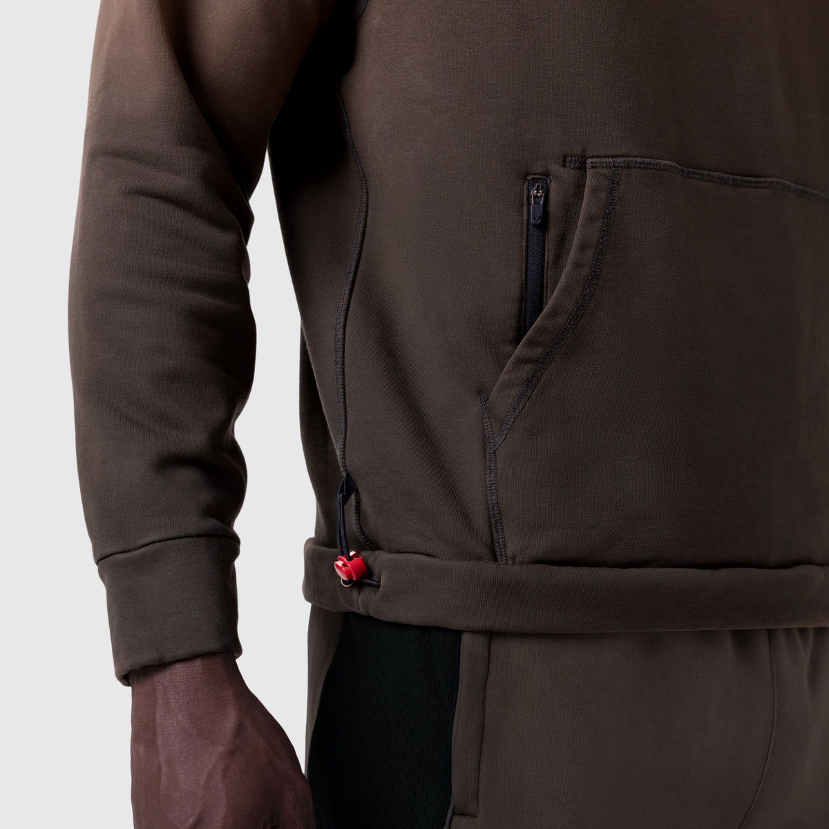 Tech-Terry Training Hoodie in dark earth, worn by model showing zipper detail and waist adjustment