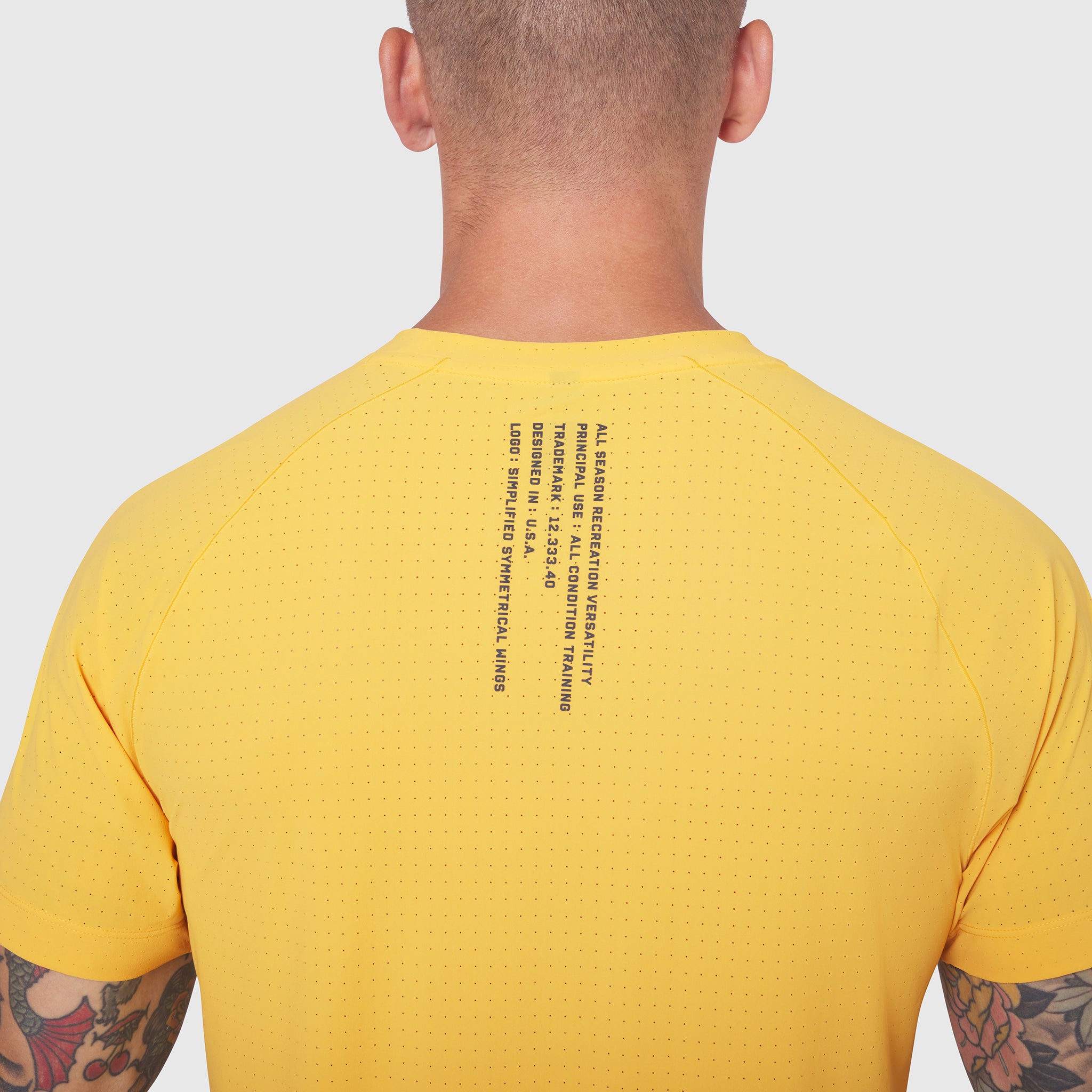 Laser-Vent Training Tee in amber yellow worn by model, back view showing perforated fabric