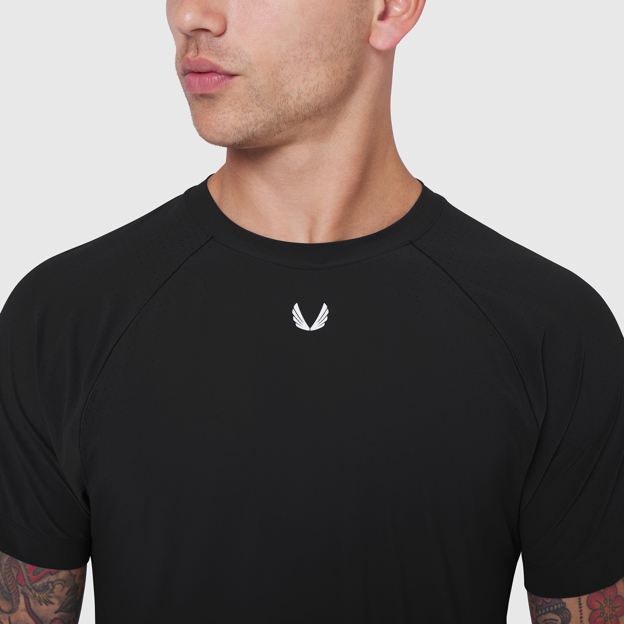 Black Laser-Vent Training Tee worn by model, front view with small white wing logo