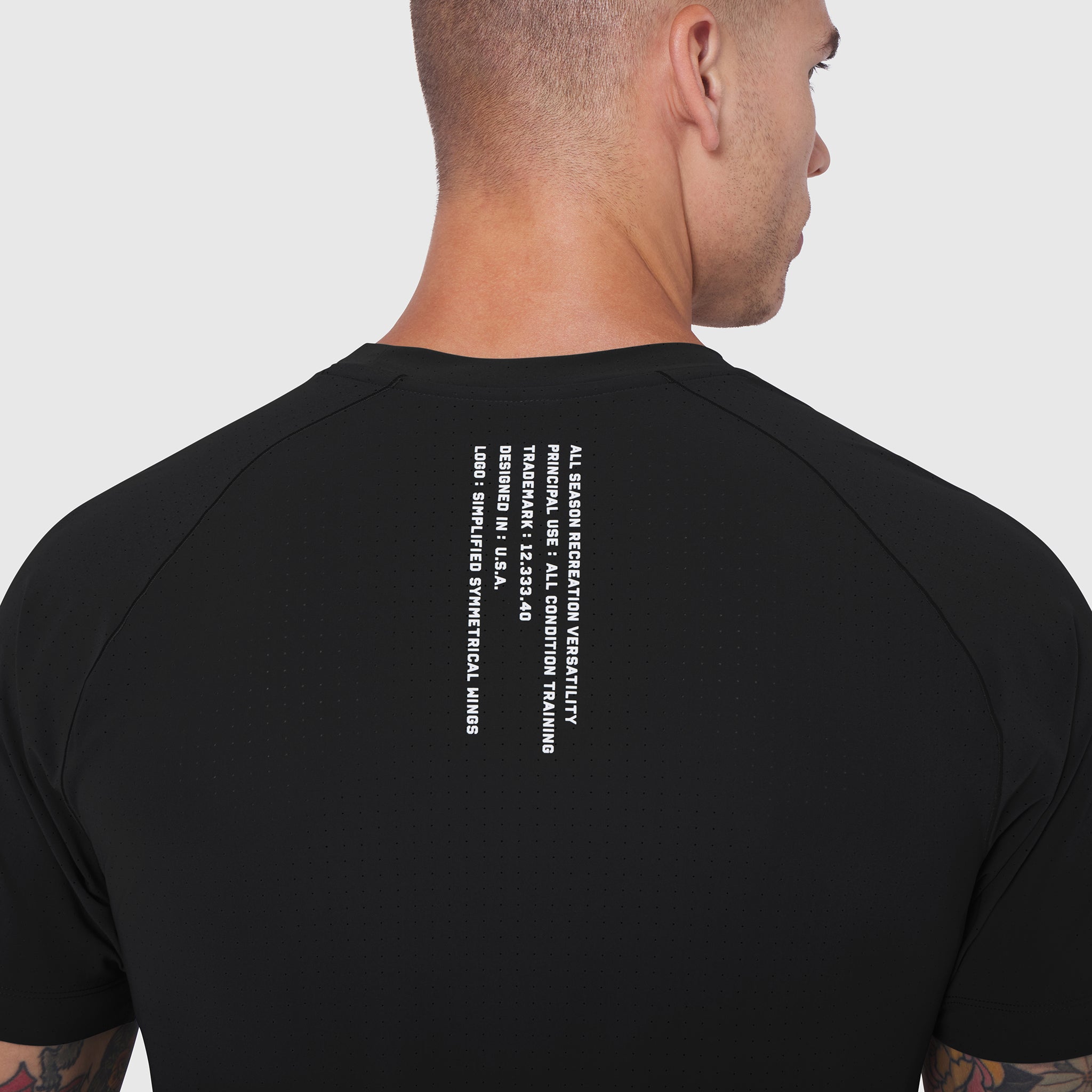 Black Laser-Vent Training Tee worn by model, back view showing text graphic