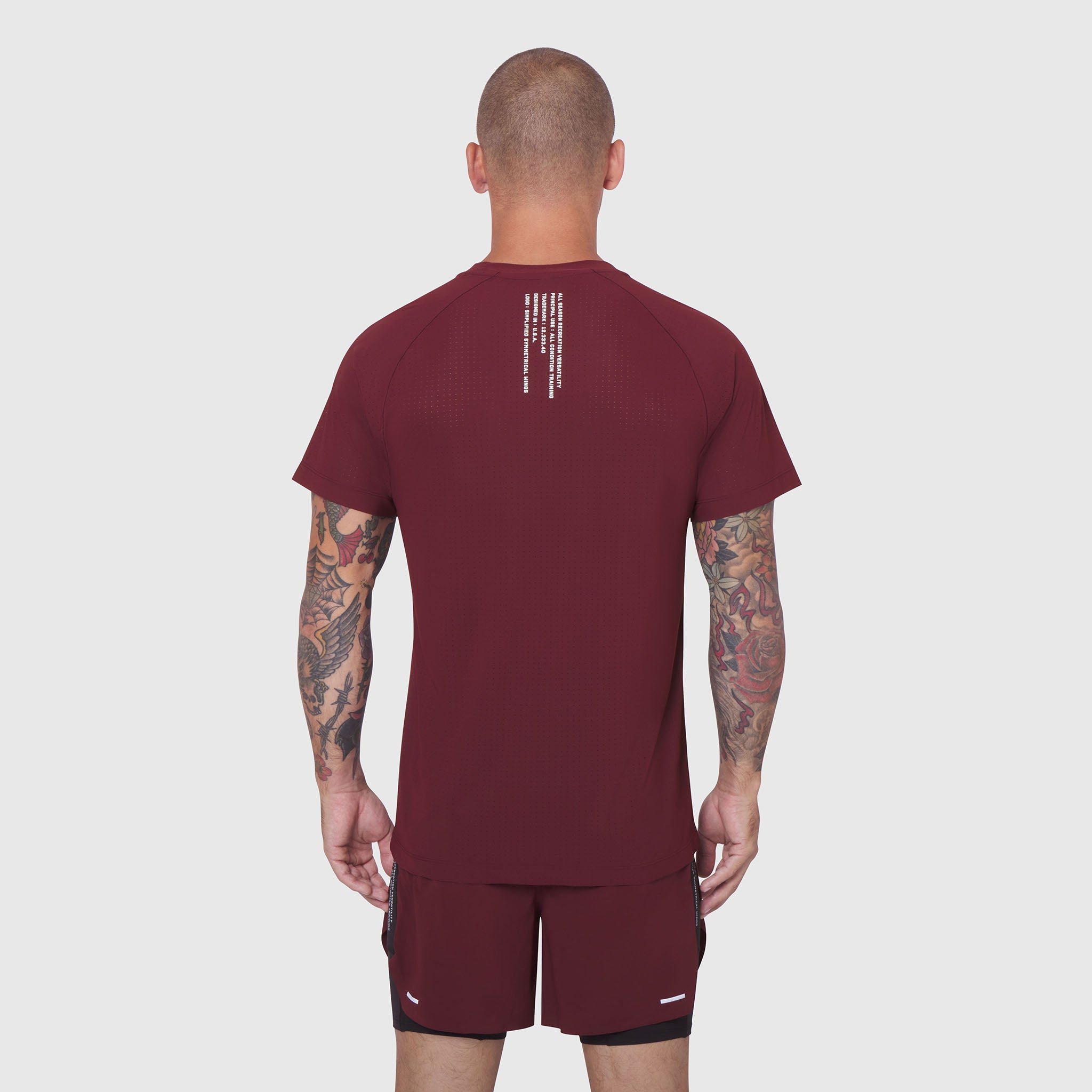 Laser-Vent Training Tee in crimson, back view on model with tattoos