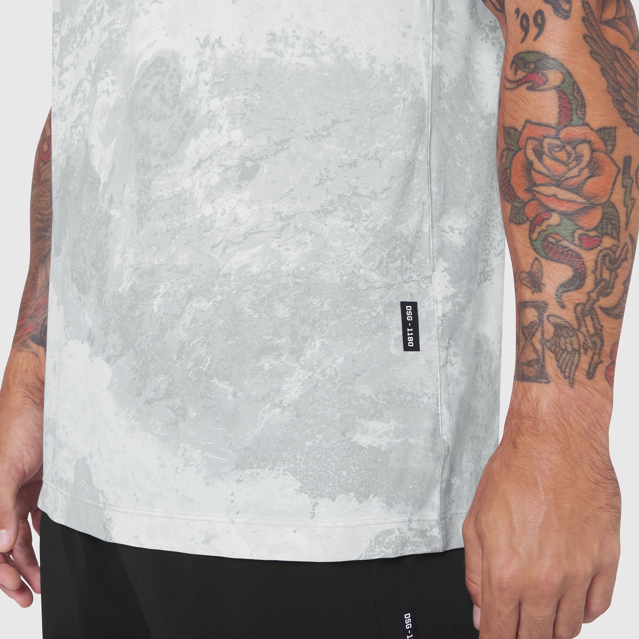 Laser-Vent Training Tee in white marble worn by model showing front view and tattoos