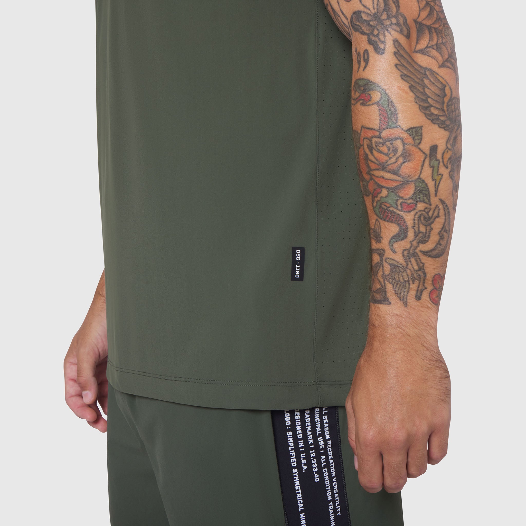 Laser-Vent Training Tee in olive worn by model showing side view with tattoo visible
