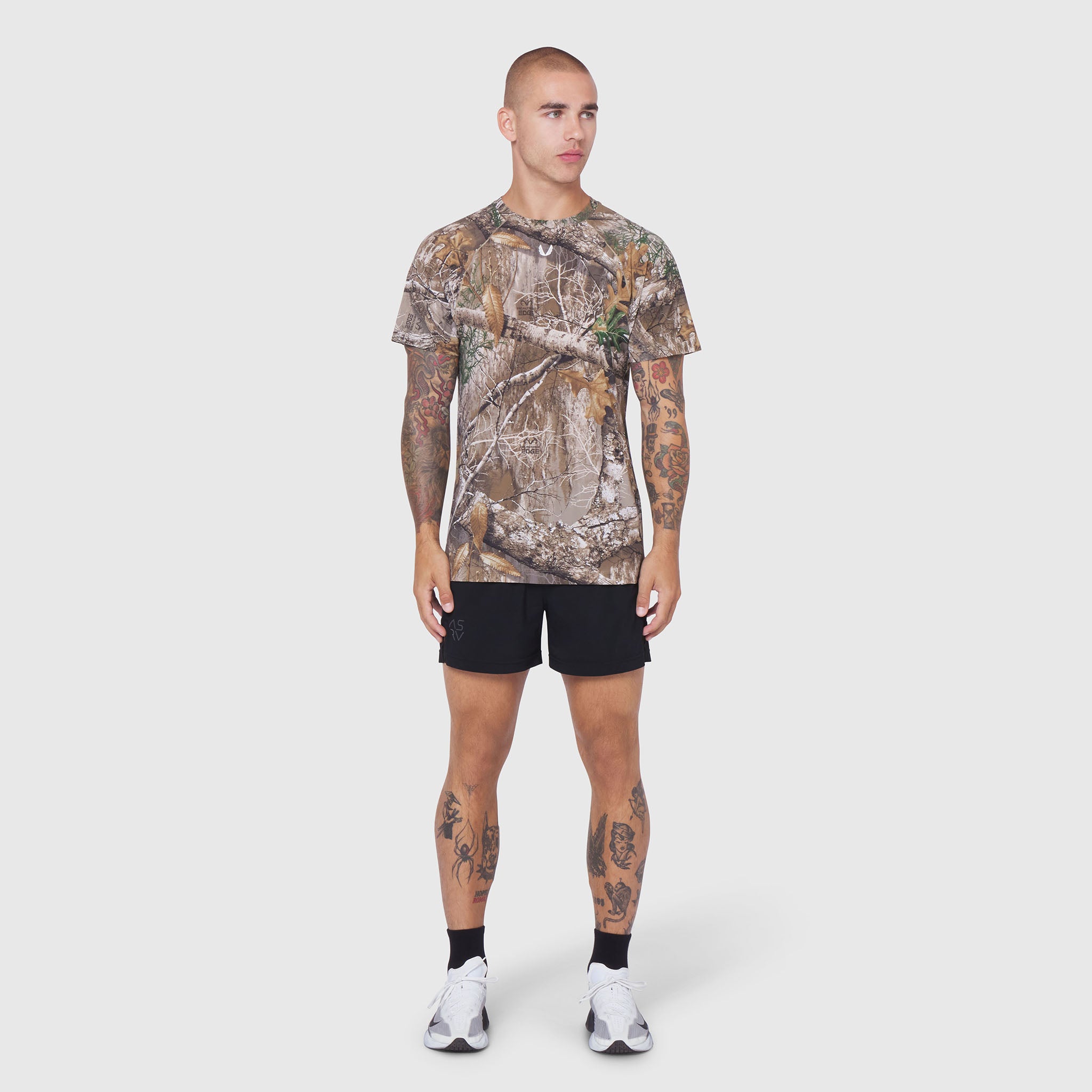 Laser-Vent Training Tee in Realtree Edge camo, worn with black shorts, front view on model