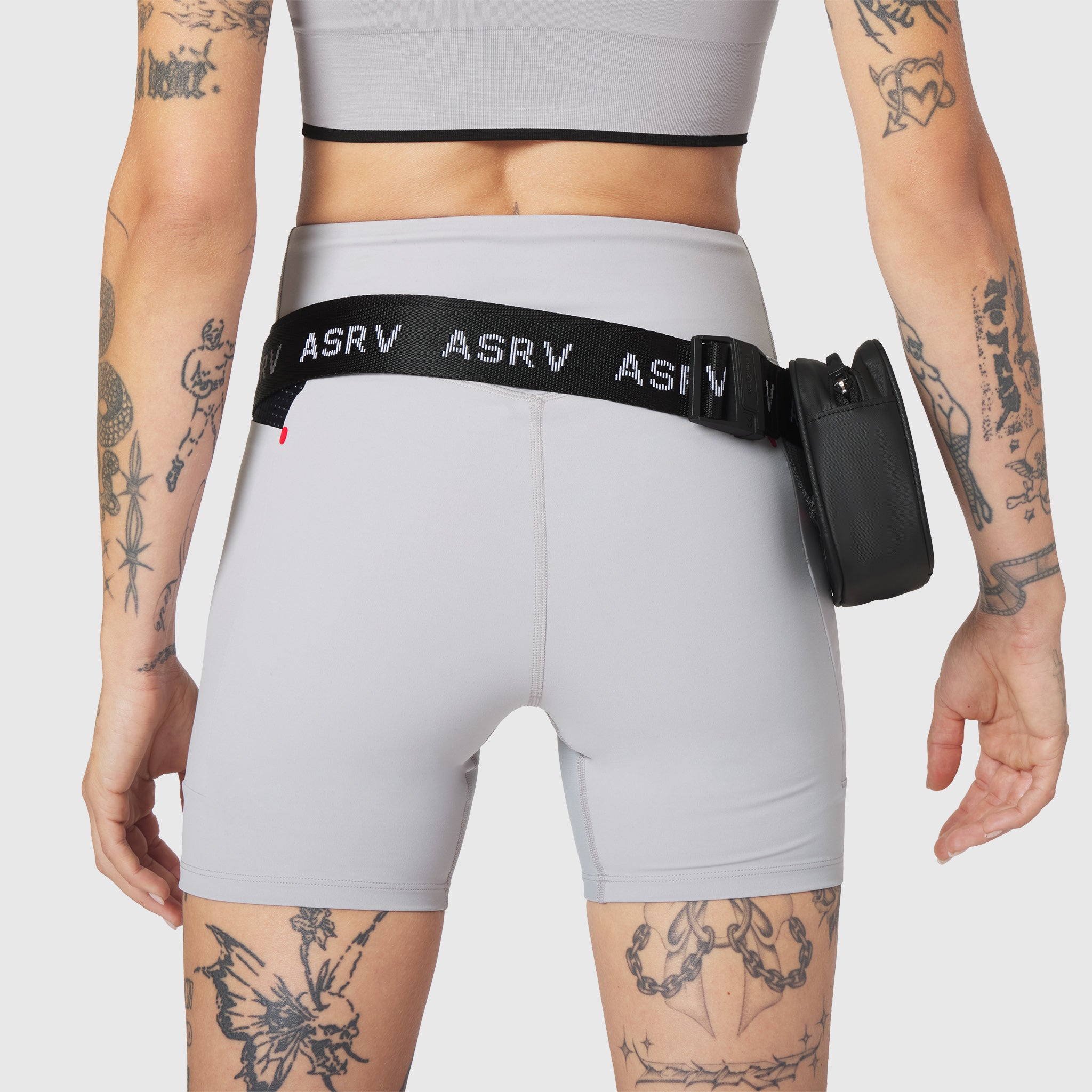 Trail Pack in black, worn on model with white shorts, back view