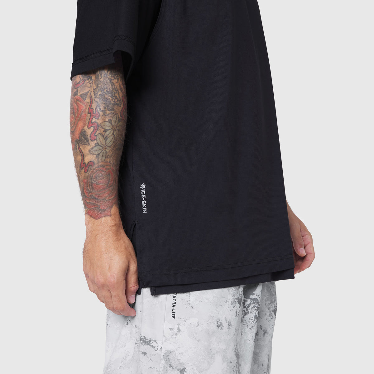 Black Supima Ice-Skin reversible tee on model with tattooed arm, side view