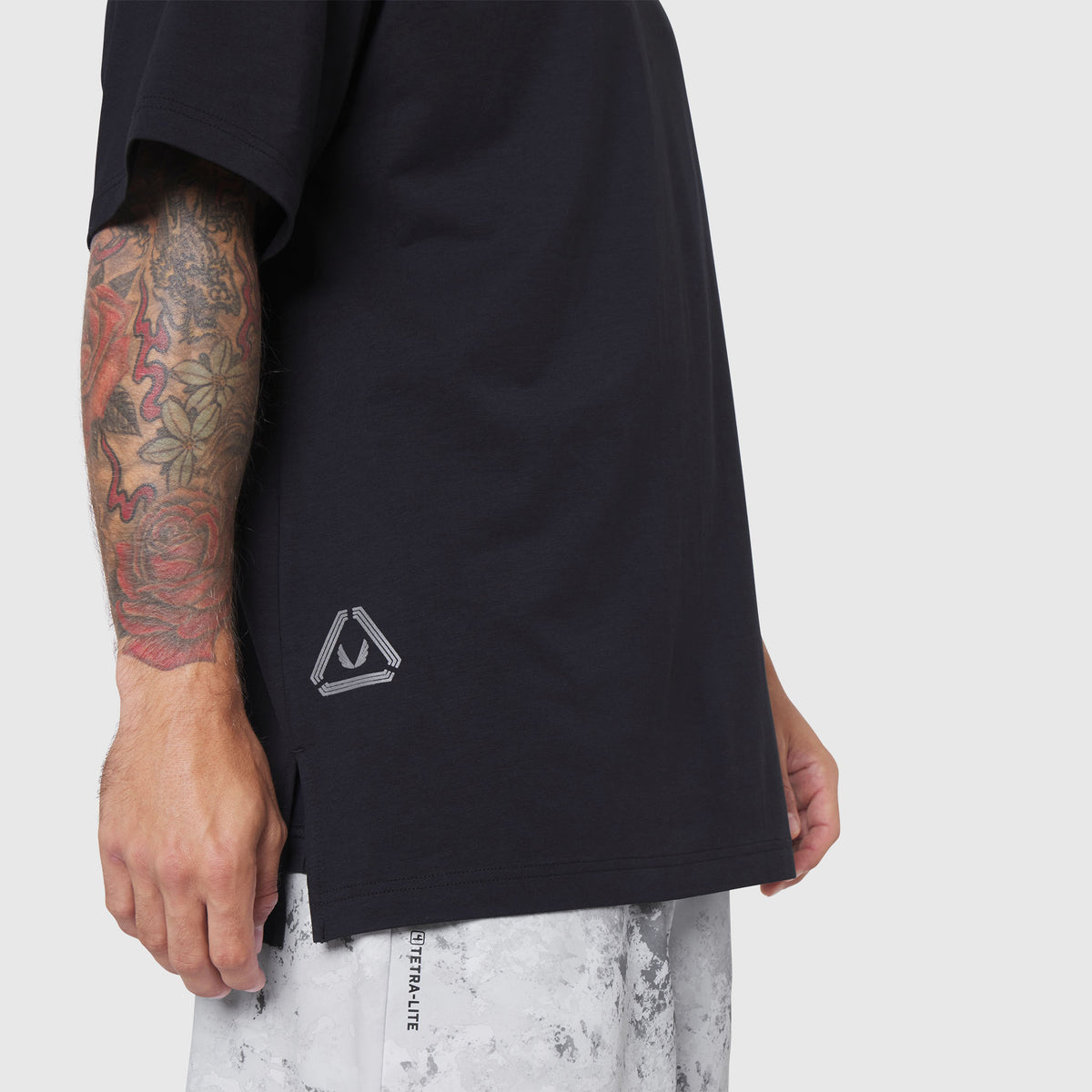 Black Supima Ice-Skin reversible tee on model, side view with tattooed arm visible