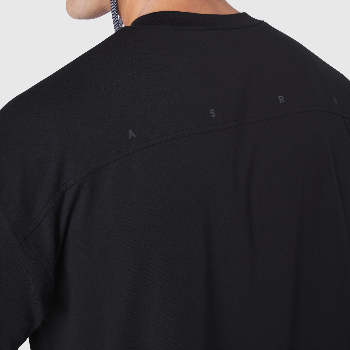 Black Supima Ice-Skin reversible tee worn by model, back view showing design details