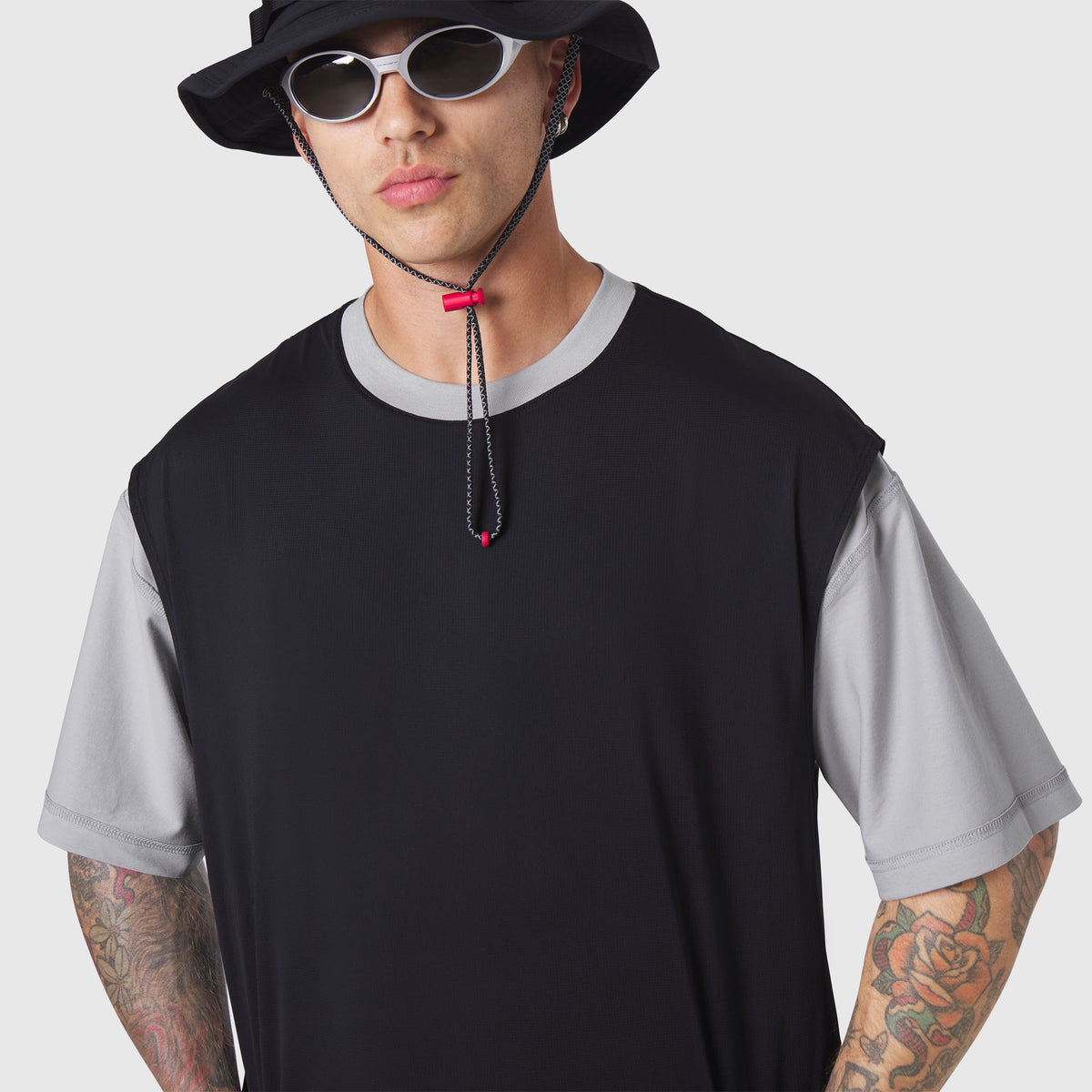 Reversible tee in black and grey worn by model, front view with accessories
