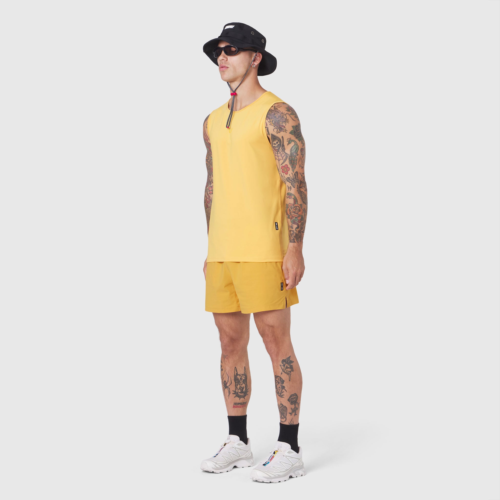 Warpflexx-Lite Training Tank in amber yellow, worn by model with shorts, front side view