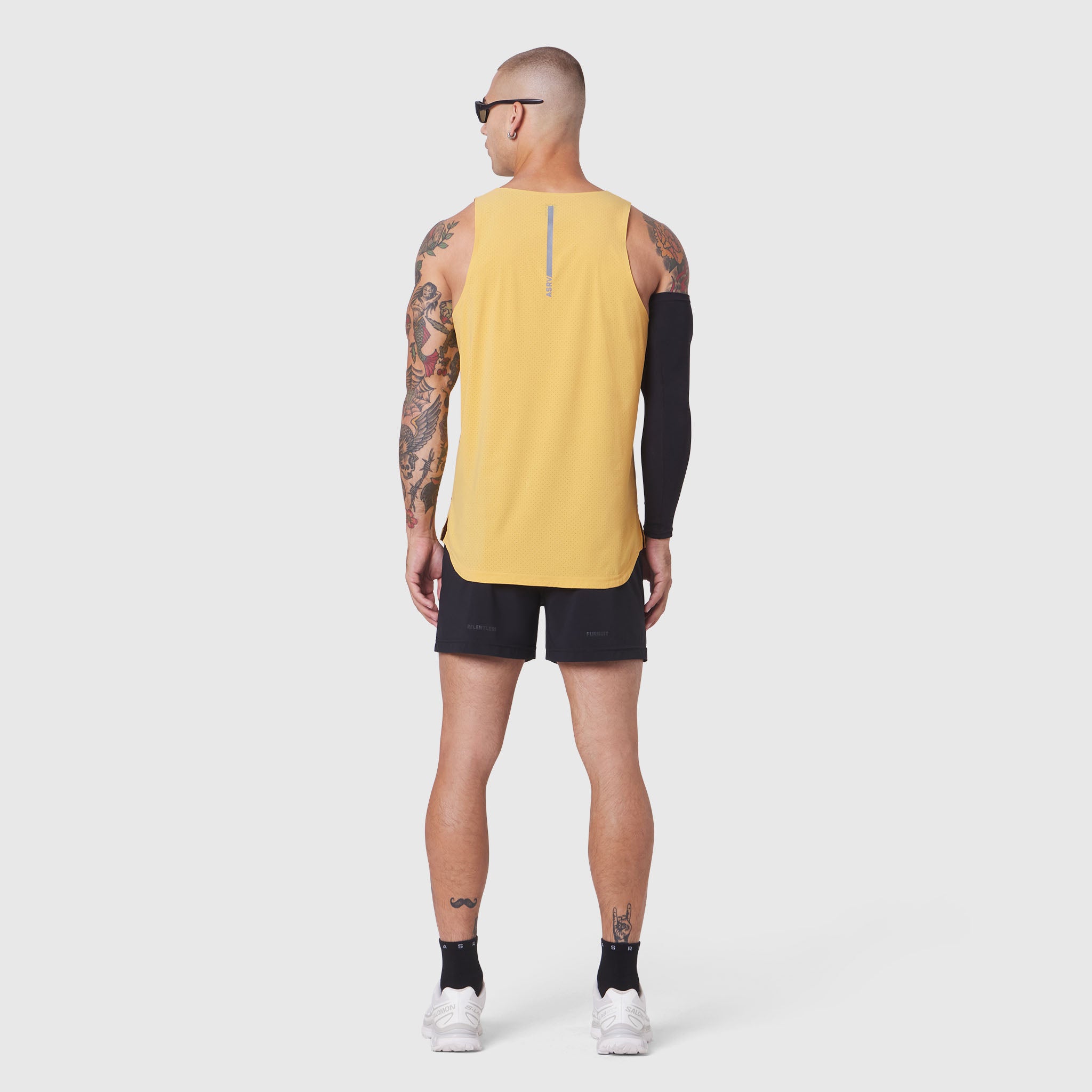 Aerotex Perforated Run Tank in amber yellow, worn by model from back, paired with black shorts