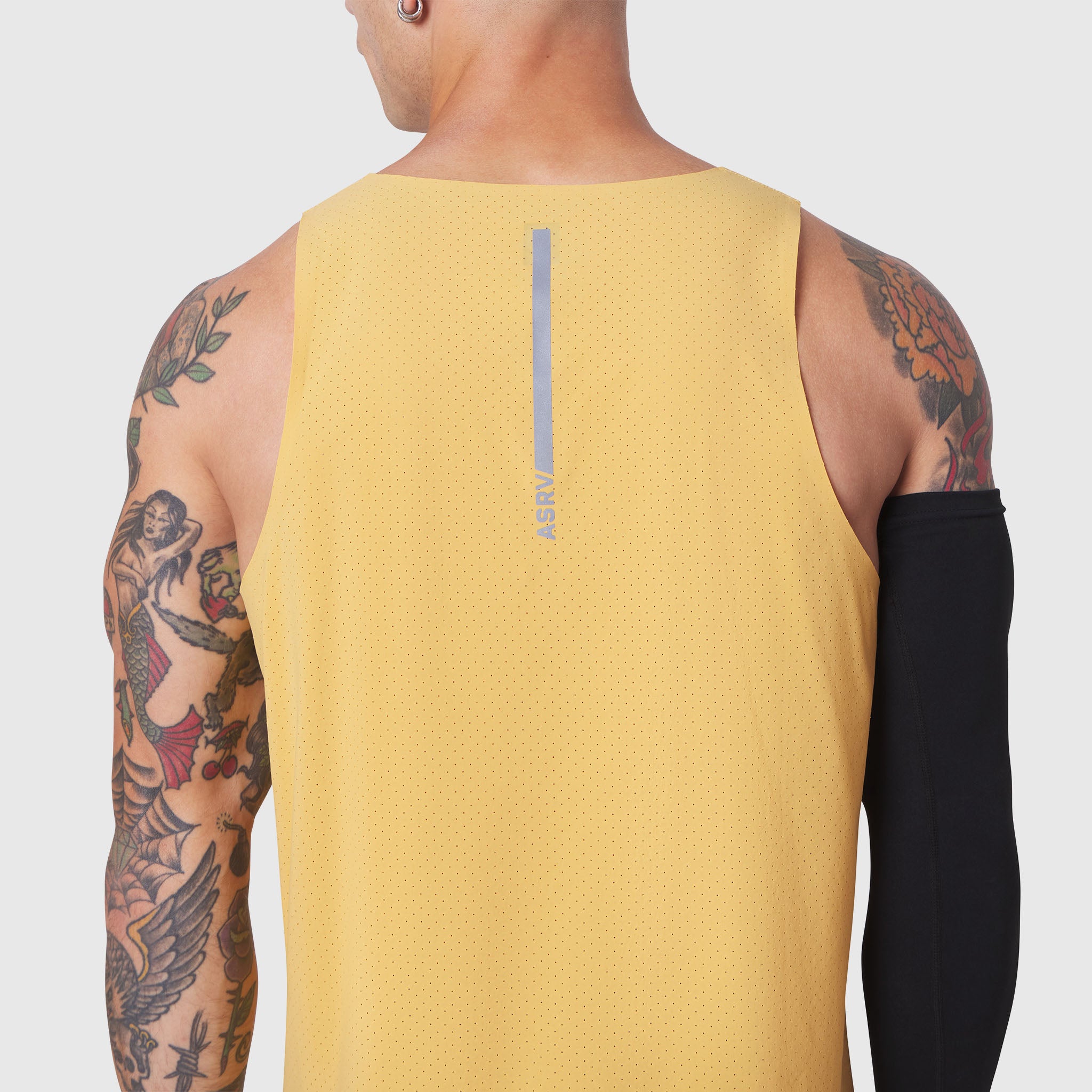 Aerotex Perforated Run Tank in amber yellow, worn by model showing back view with reflective logo