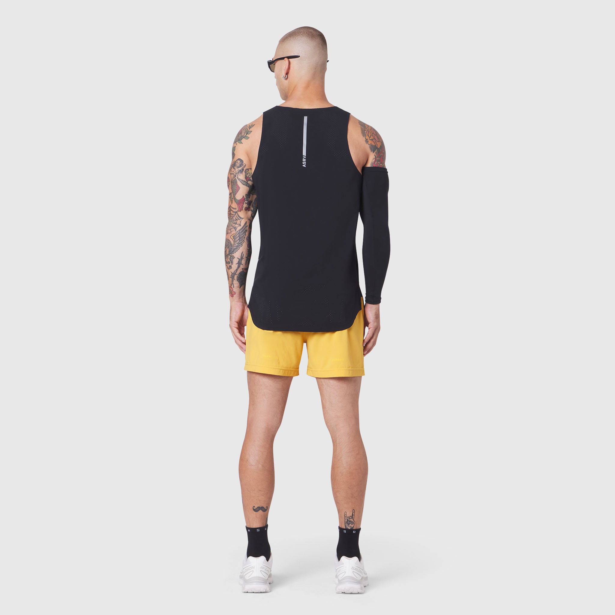 Aerotex Perforated Run Tank in black with yellow shorts, back view on model