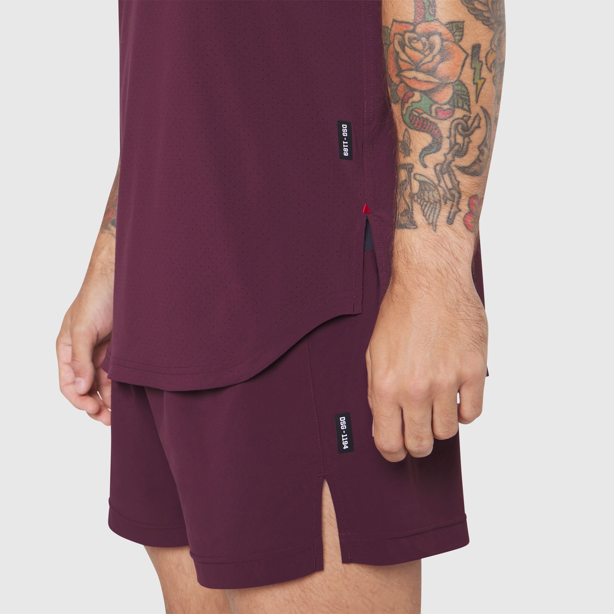 Aerotex Perforated Run Tank in merlot worn with matching shorts, side view