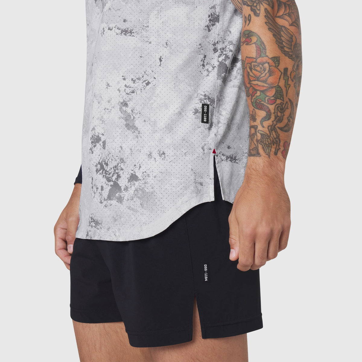 Aerotex™ Perforated Run Tank in Sedona Snow Camo worn with black shorts, side view