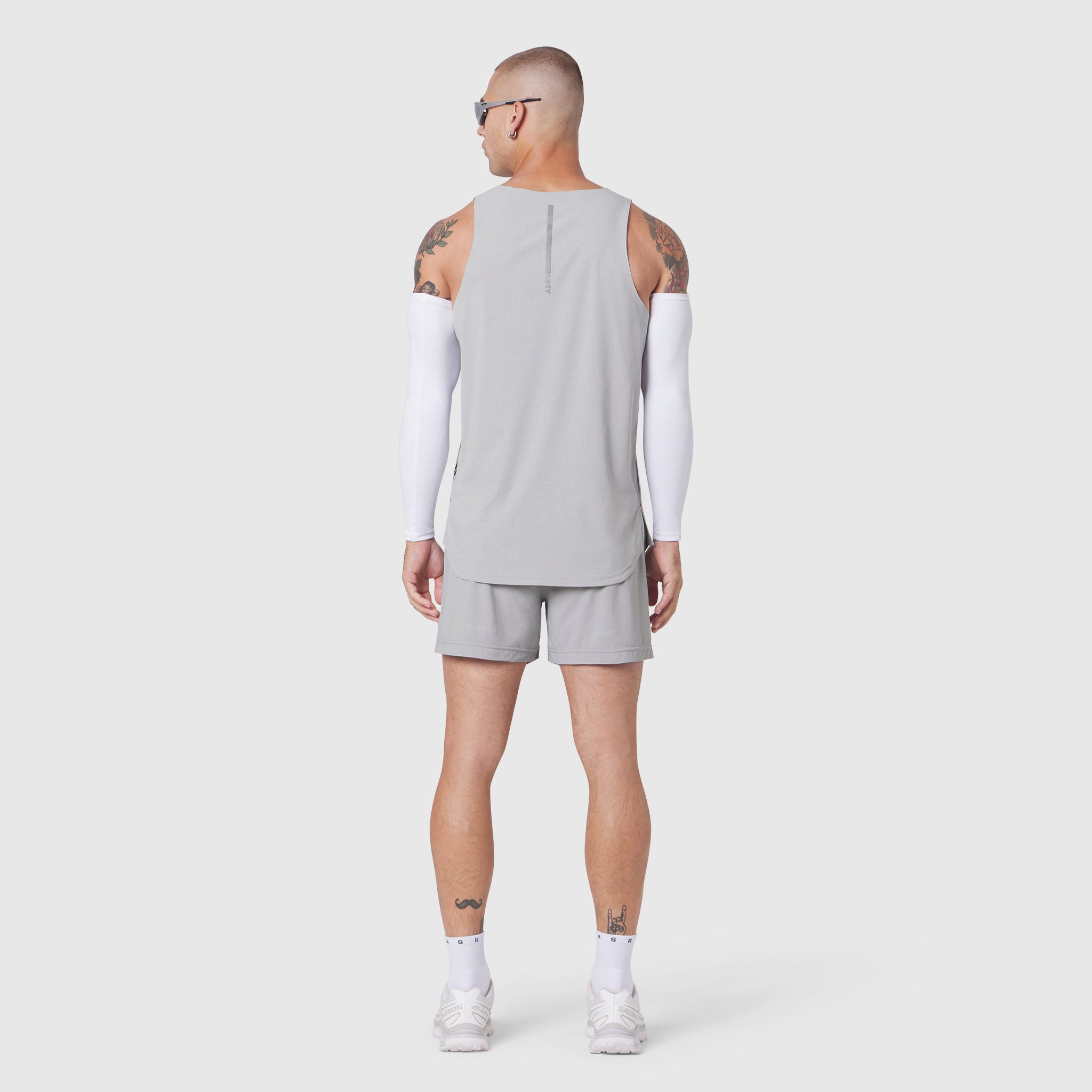 Aerotex Perforated Run Tank in slate grey worn by model, back view with white arm sleeves