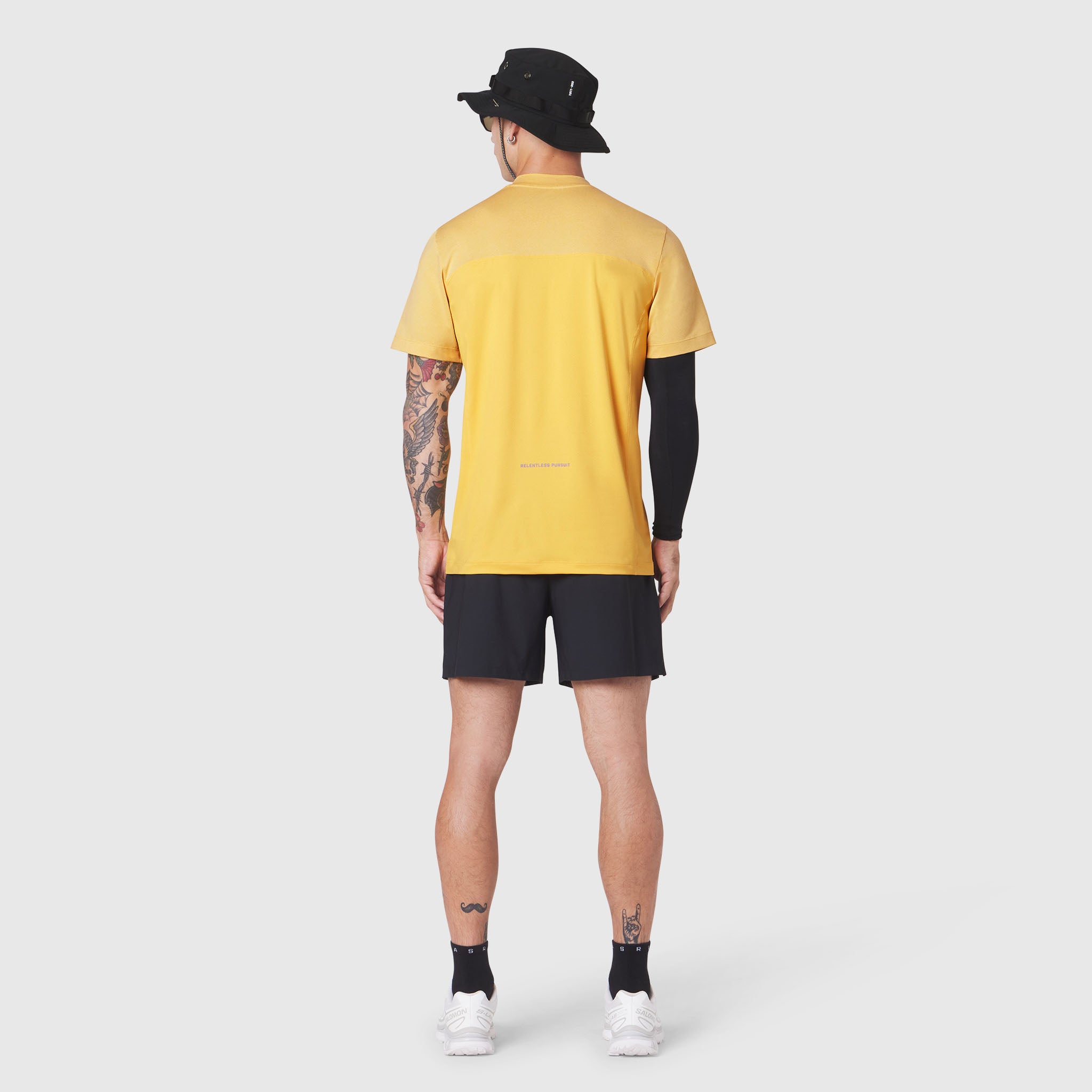 AEROSILVER® UPF50+ Run Tee in amber yellow worn by model from back, paired with black shorts