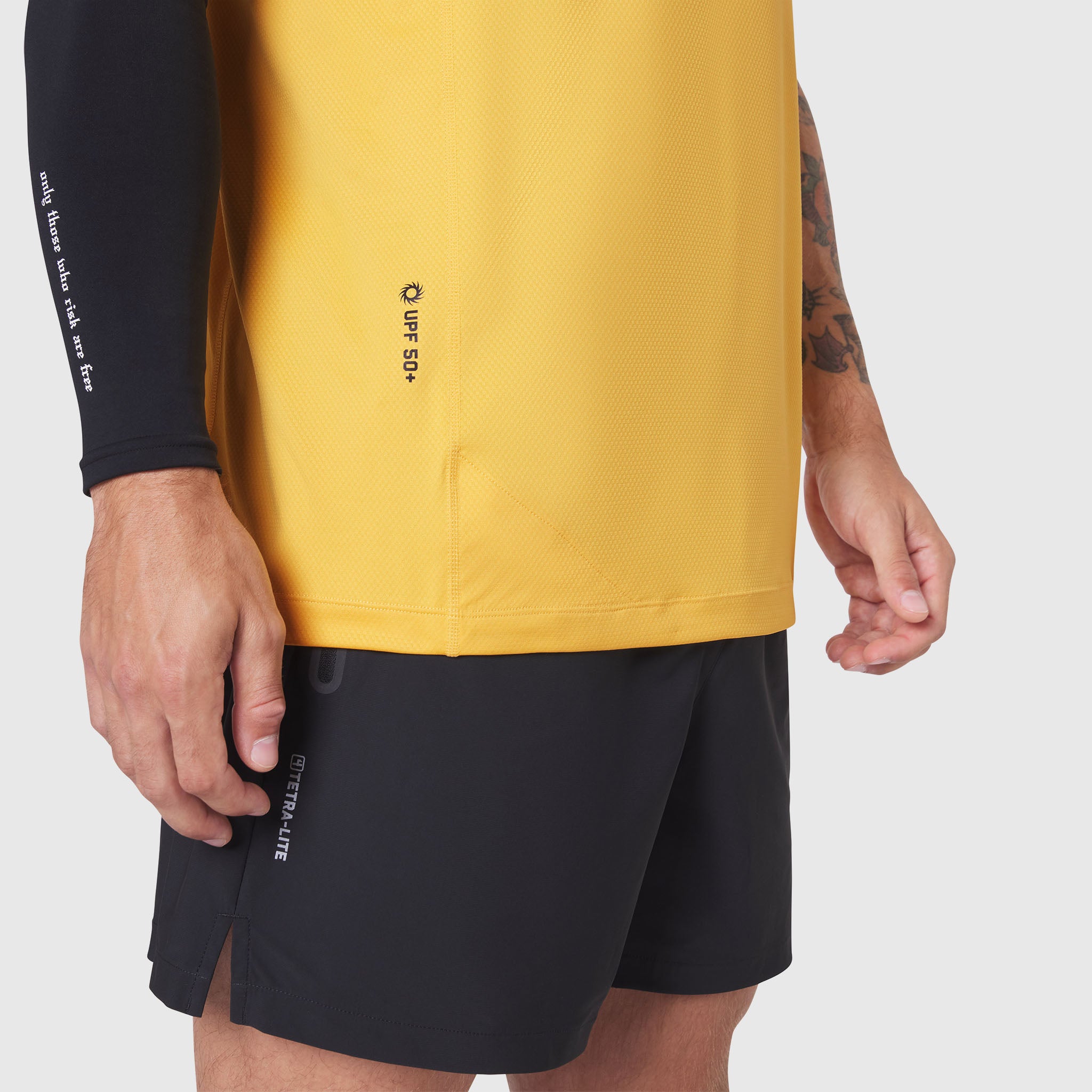 AEROSILVER UPF50+ Run Tee in amber yellow worn by model with black shorts, front view