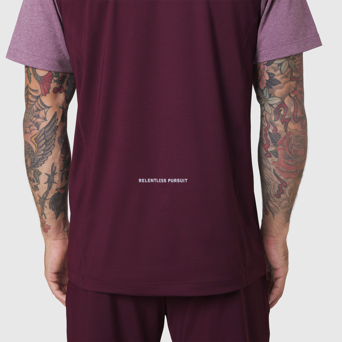 AEROSILVER® UPF50+ Run Tee in merlot, back view on model with visible 'Relentless Pursuit' text