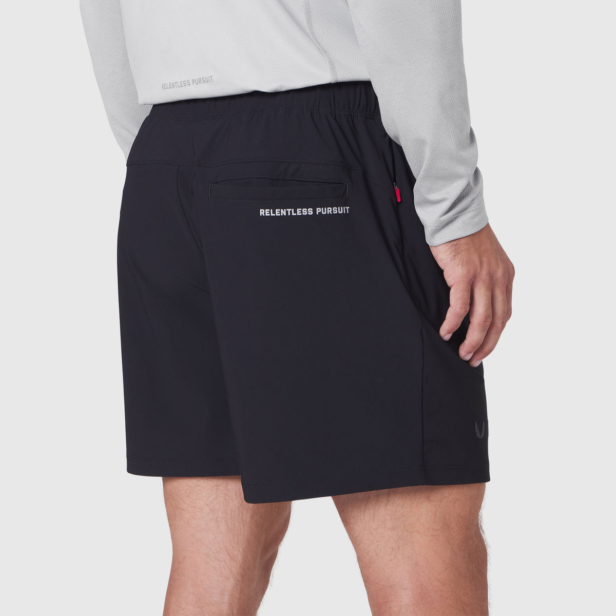 Revolutional Training Short in black, worn by model showing back pocket detail with 'Relentless Pursuit' branding