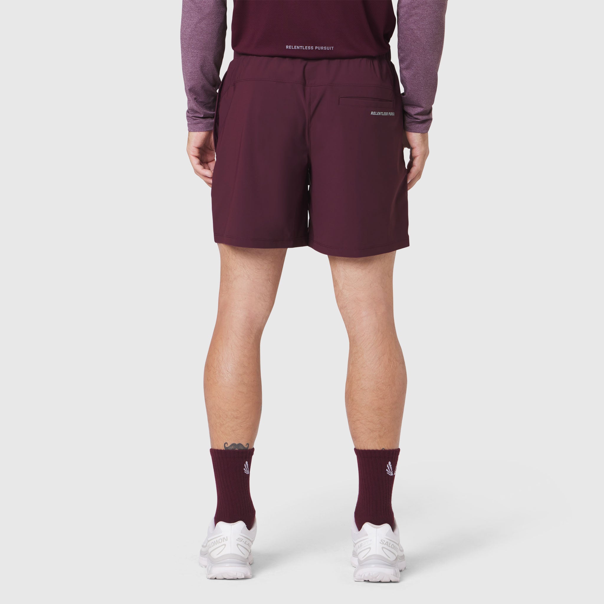 Revolutional Training Short in merlot, rear view on model wearing matching long-sleeve top and socks