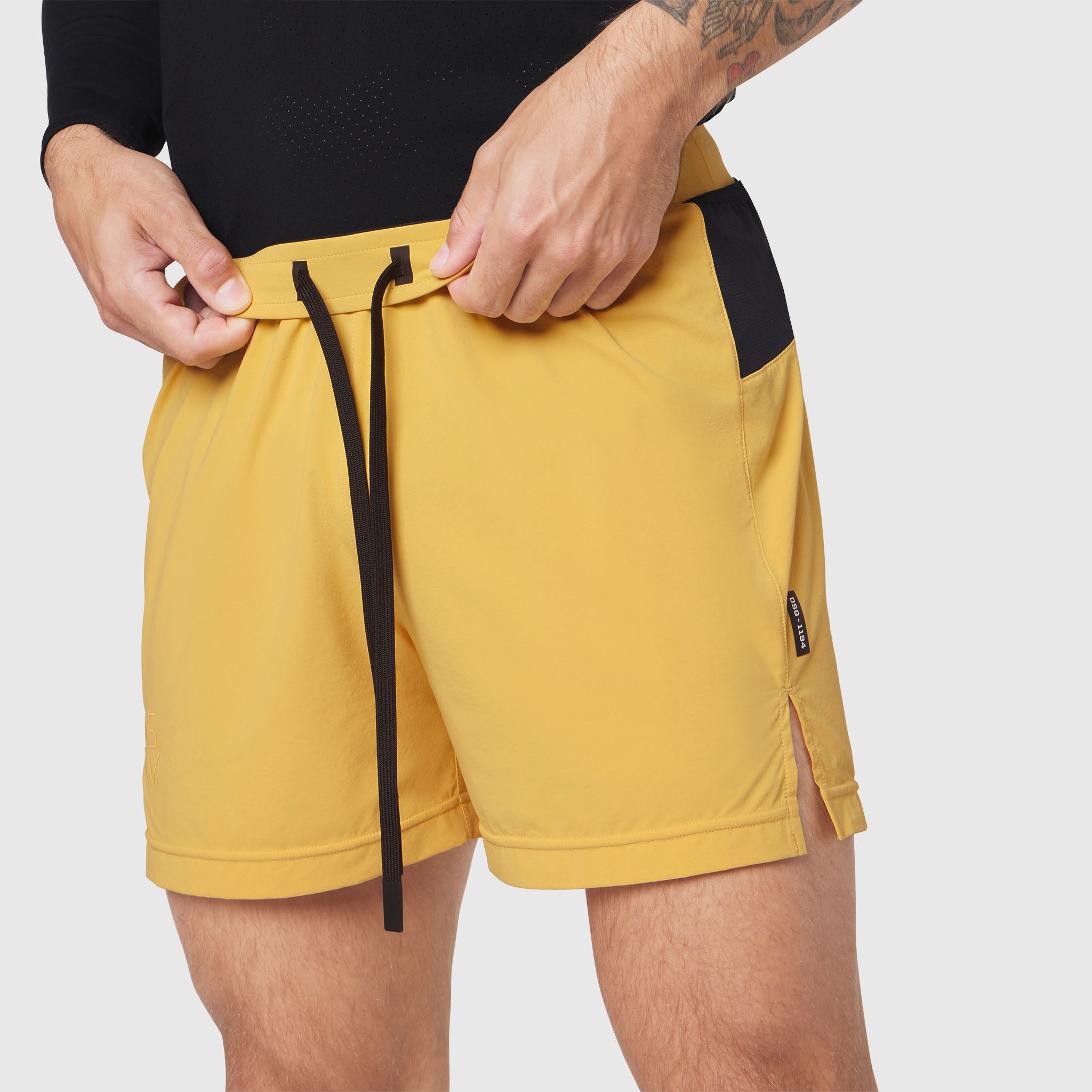 Aerotex Distance Run Short in amber yellow, worn by model adjusting drawstring