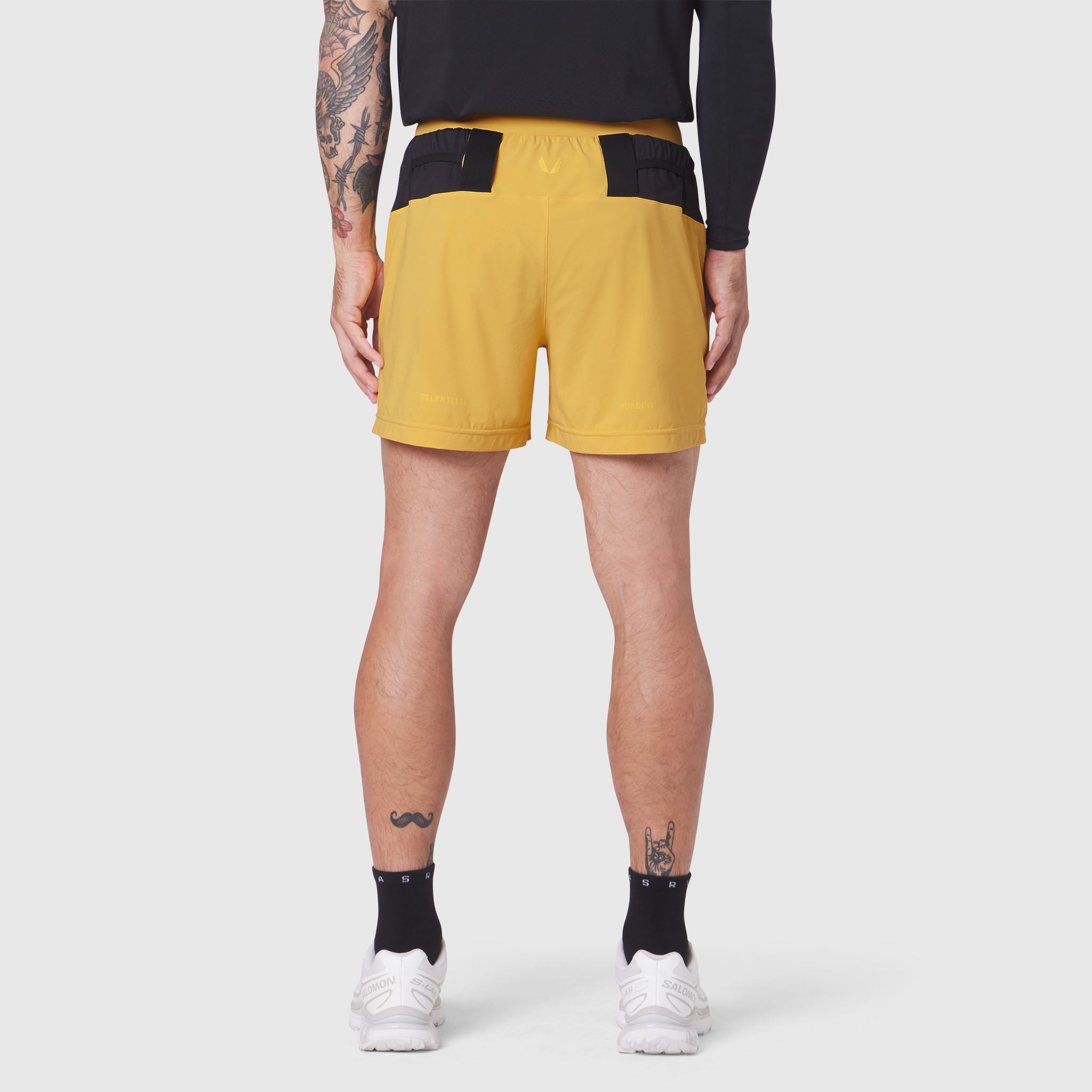 Aerotex Distance Run Short in amber with black trim, rear view on model