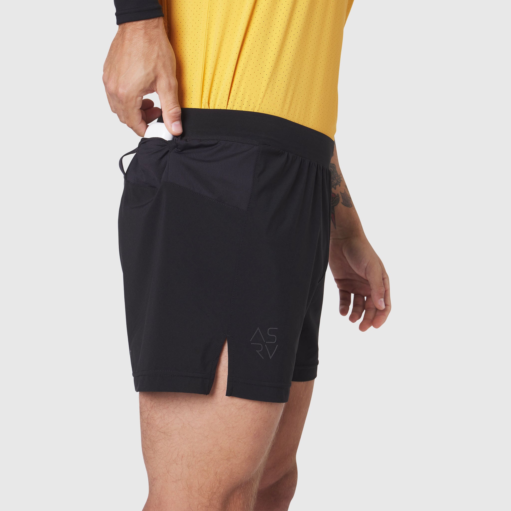 Aerotex Distance Run Short in black, worn by model showing side view with hand in pocket