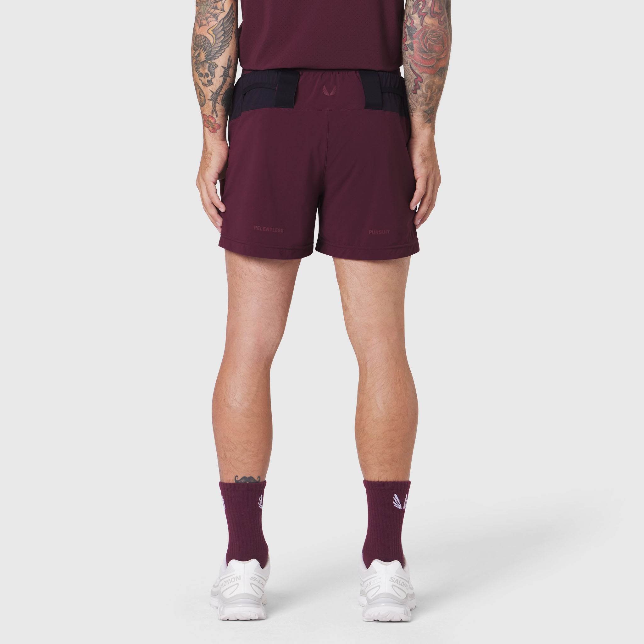 Aerotex Distance Run Short in merlot, rear view on model wearing matching tank and socks
