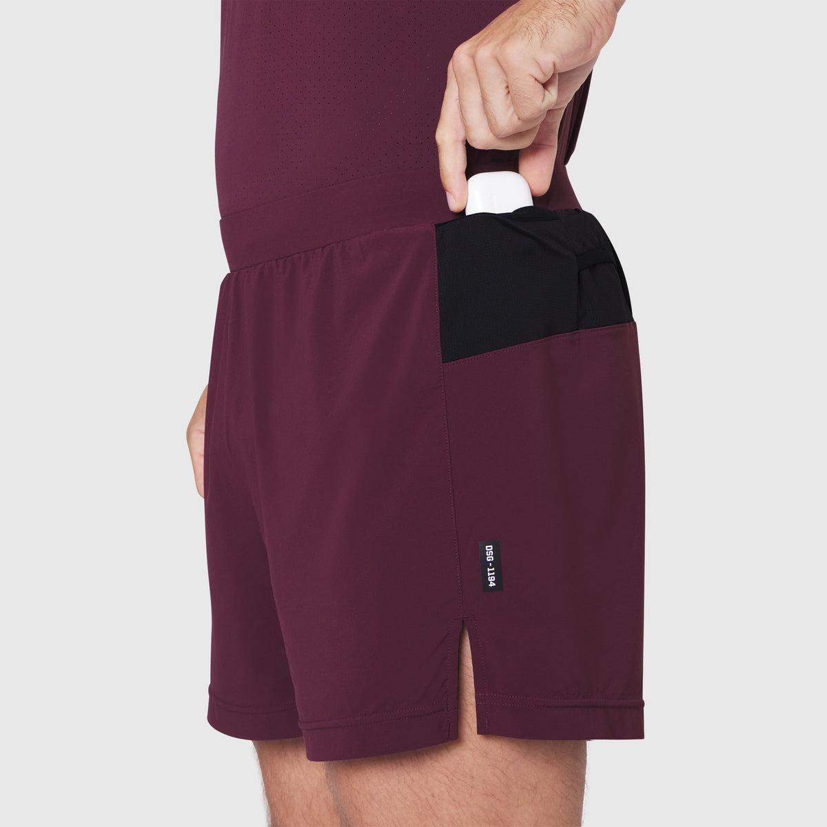 Aerotex Distance Run Short in merlot, model wearing shorts with hand in pocket