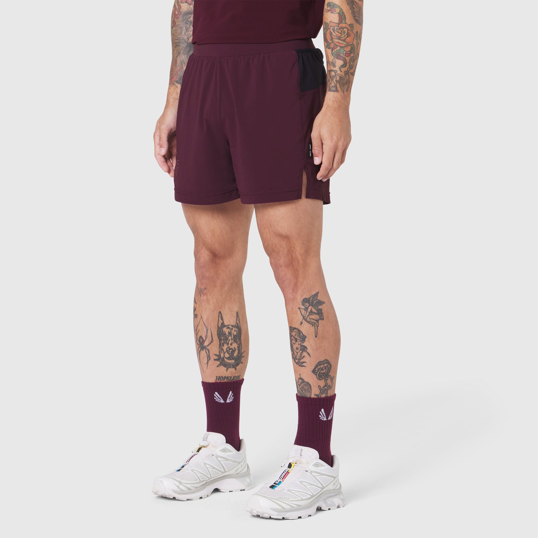 Aerotex Distance Run Short in merlot worn by model with white sneakers and maroon socks, front view