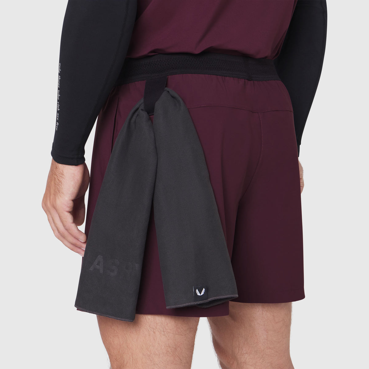 TETRA-LITE® 5" Linerless Training Short in merlot, worn by model, back view with towel