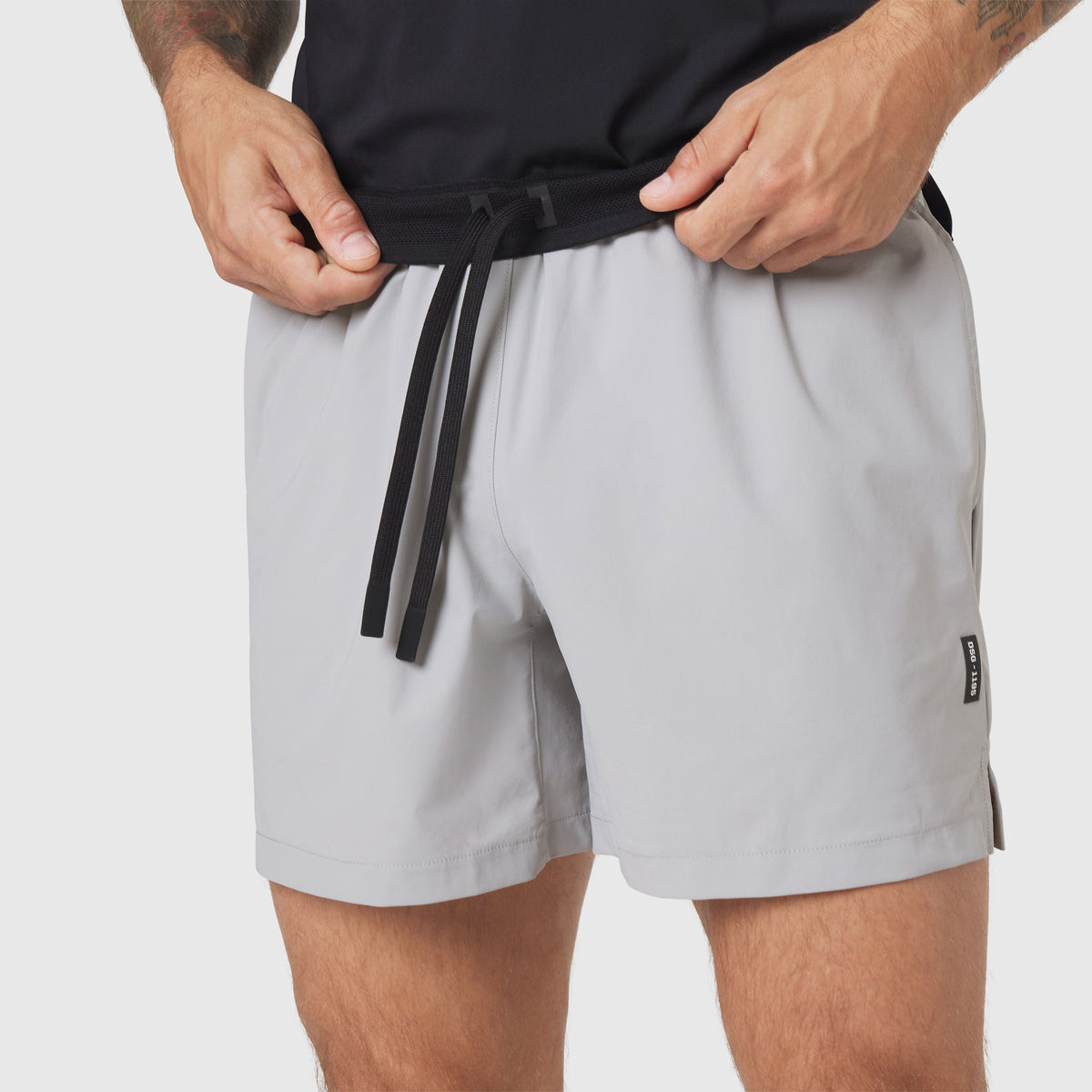 TETRA-LITE® 5" Linerless Training Short in Slate Grey, model wearing and adjusting drawstring