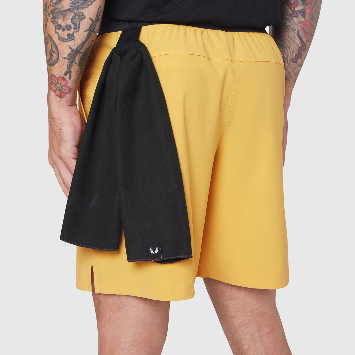 TETRA-LITE® 7" Linerless Training Short in amber, worn by model from behind with black towel