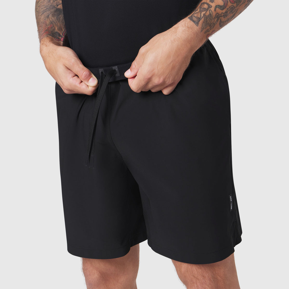 Tetra-Lite 7" Linerless Training Short in black, worn by model adjusting drawstring
