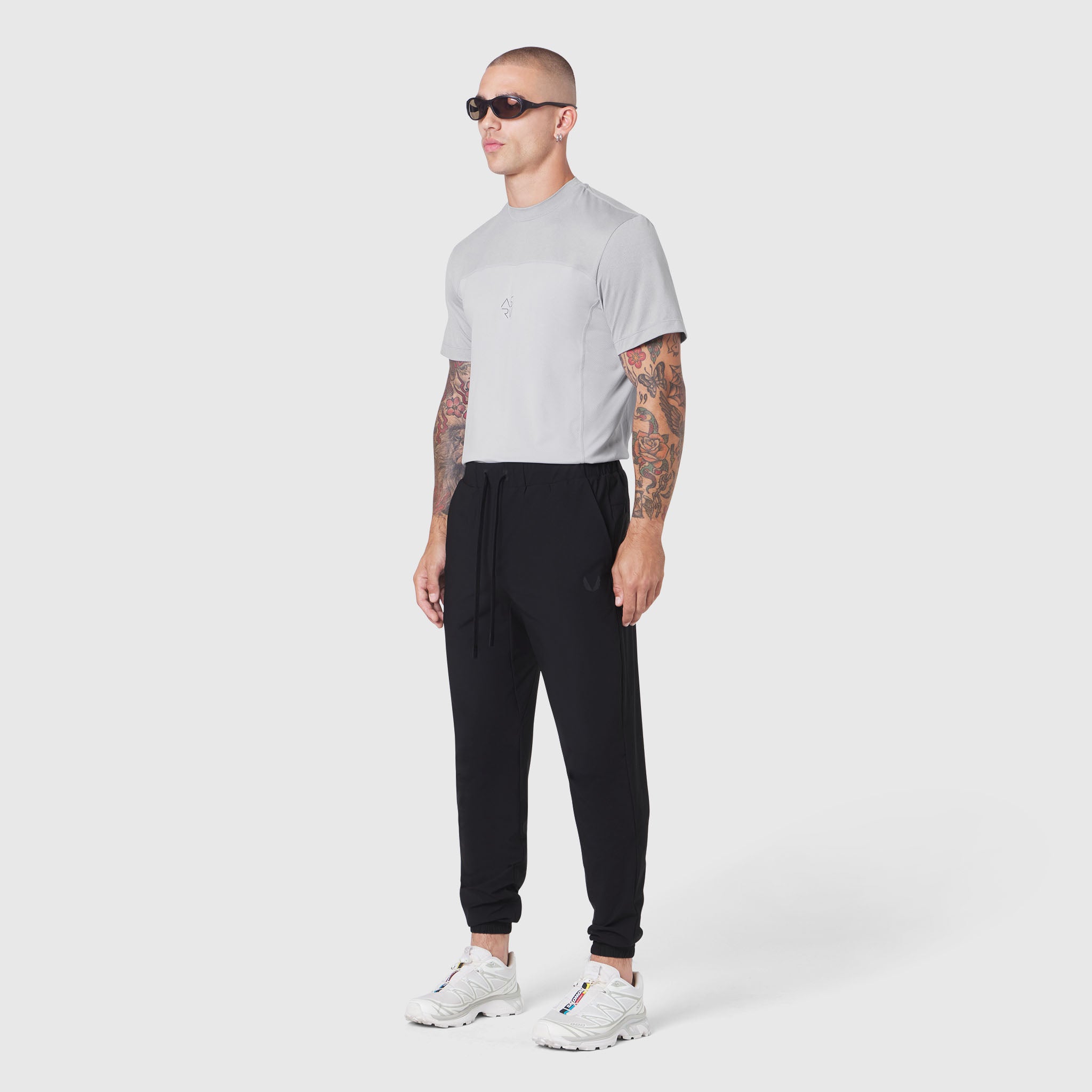 TETRA-LITE® Training Jogger in black, worn with grey t-shirt and white sneakers, full-length side view