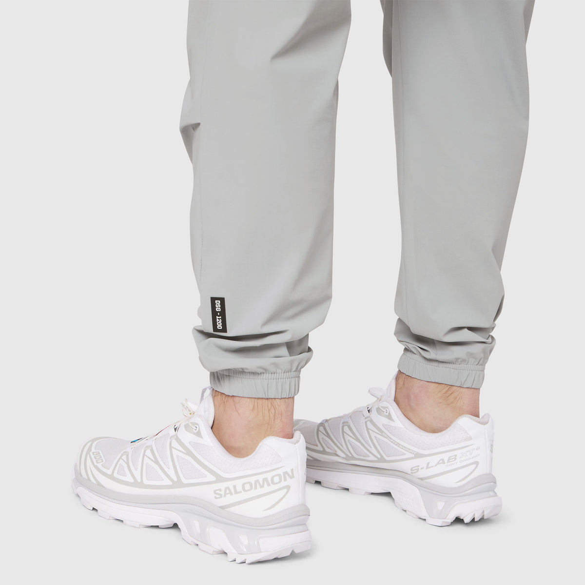Slate grey Tetra-Lite training jogger worn with white sneakers, calf detail view