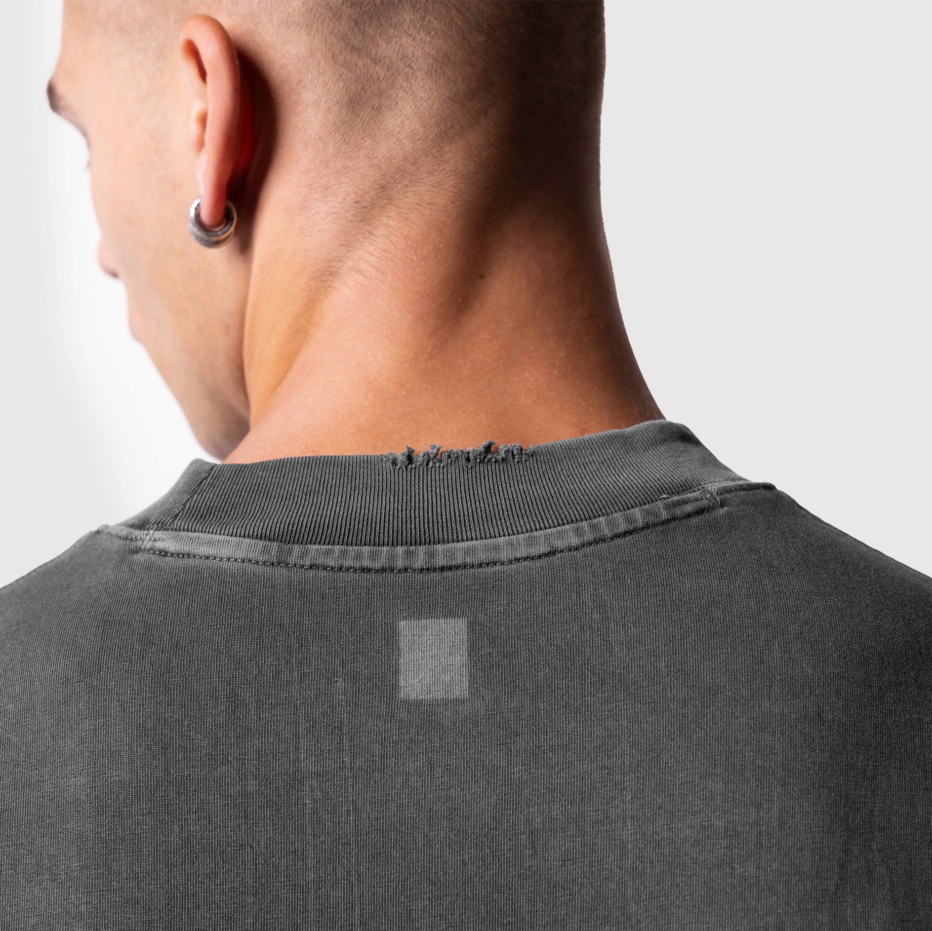Model wearing ASRV Tech Essential Oversized Boxy Tee in Faded Grey, back view detail shot