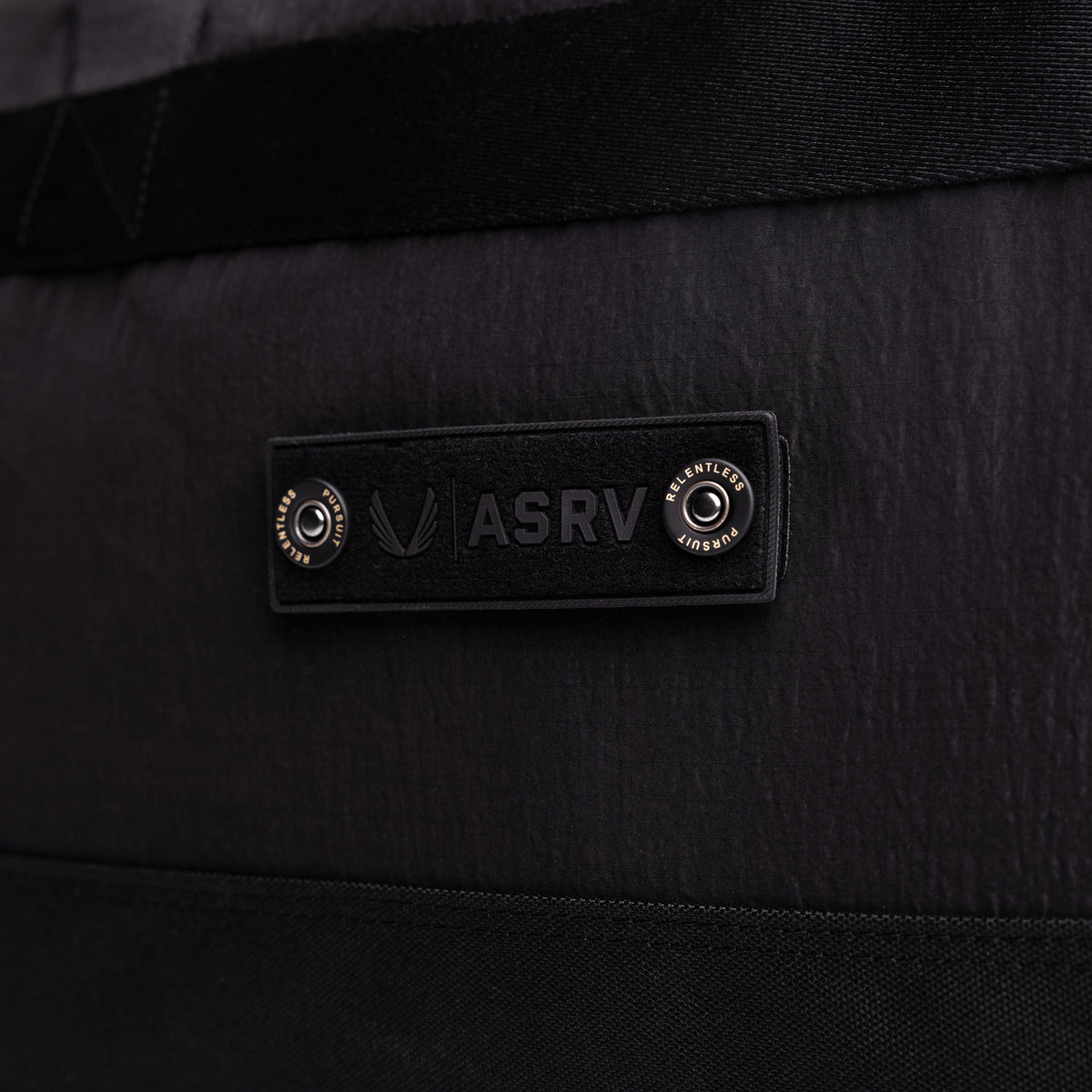 Flatlay 1234 Ripstop Duffle Bag in black, detail view of ASRV logo label