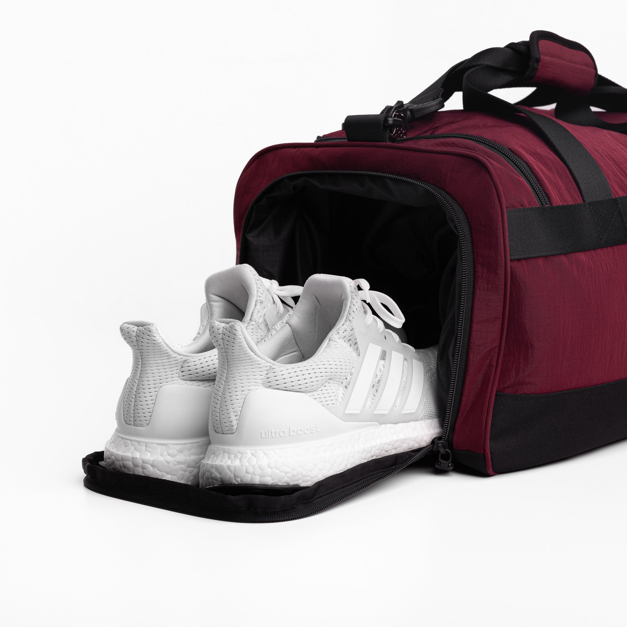Flatlay 1234 Ripstop Duffle Bag in Crimson with white sneakers, front view