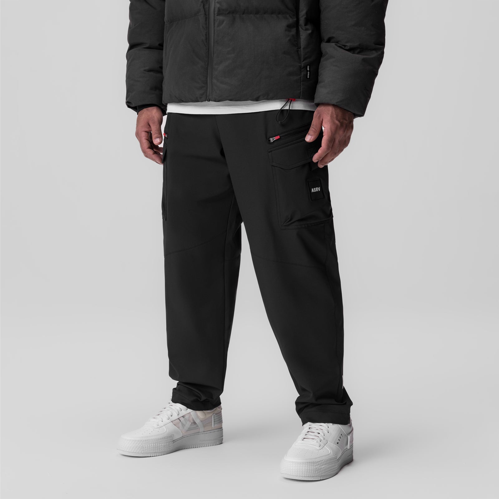Black Tetra Weather-Ready City Pant worn with white sneakers and black puffer jacket, front view