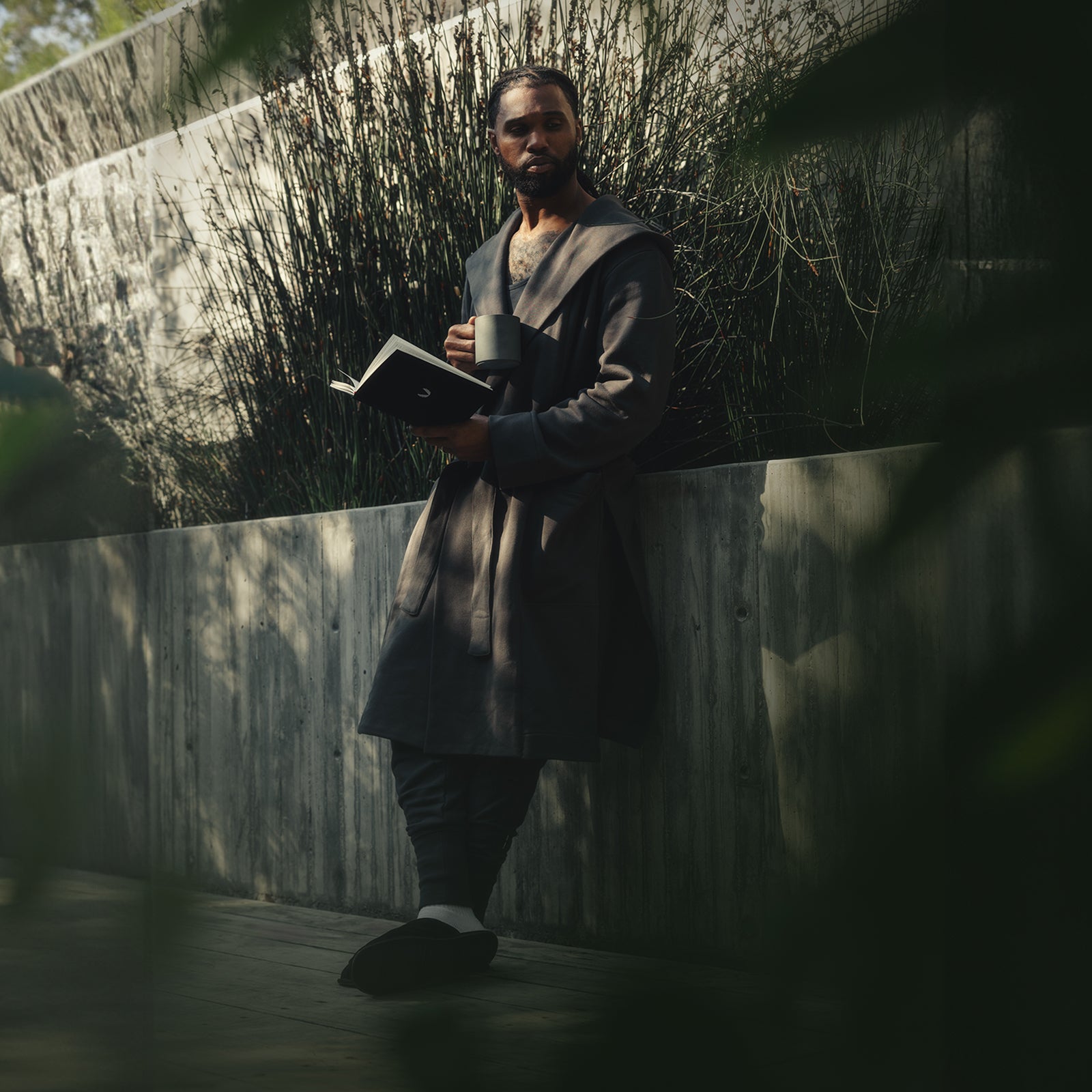ASRV x Walden Heavyweight Robe in carbon, worn by model holding book in outdoor setting